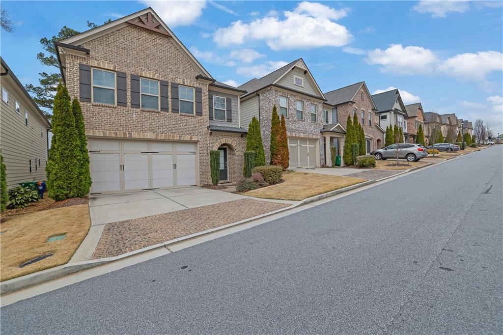 View of front of home featuring concrete driveway, brick siding, and an attached garage