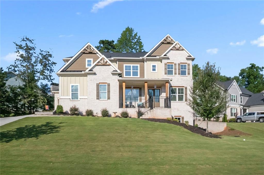 **Better Than New!** Discover this stunning two-year-old home with custom upgrades in the highly sought-after Traditions of Braselton community. This spacious residence offers five bedrooms and four full bathrooms, providing ample room for a large family, home office, or guests.
As you enter through the elegant double front doors, you'll be greeted by a beautifully designed space. The expansive, separate dining room features a connected Butler’s Pantry, perfect for effortless entertaining. Adjacent to this is a charming glass-enclosed area, ideal for a quiet reading den, a convenient workout space, or a stylish home office.
The great room is truly breathtaking, boasting a soaring 24-foot wood-beamed ceiling. Natural light floods the room through windows on both the main level and high above. A stone fireplace with a paneled wall and built-ins adds warmth and comfort to the space.
The kitchen is a chef’s dream, open and bright with quartz countertops, a beautiful textured tile backsplash, and Viking stainless steel appliances. A pot filler over the stove enhances cooking convenience. The oversized island offers plenty of seating, and the keeping room can serve as an additional breakfast area. The main level also includes a guest bedroom and a beautifully appointed full bath.
Step outside to the covered living area, which leads to a firepit and offers stunning golf course views, expanding your entertainment options. The unique oversized primary suite features a wood-planked tray ceiling, an upscale fan, a sitting area, and an ensuite bathroom with double vanities, a soaking tub, and a spacious shower with a rain showerhead. The walk-in closet, complete with a center island, provides ample storage for all your clothing needs.
Iron balusters lead up to the loft, which overlooks the great room. Each bedroom is generously sized and has access to private bathrooms, with elegant accent walls adding a touch of sophistication. A three-car garage (two-car plus an additional one-car) and a spacious driveway offer abundant parking for family and guests. The full unfinished basement, with high ceilings and plumbing for a bath, offers endless possibilities. With a private entrance, it can be transformed into extra living space or a complete second apartment.
Enjoy the convenience of a golf cart to explore the community's amenities, including swimming, tennis, pickleball, a playground, and a clubhouse. The vibrant social activities make this a highly desirable community. Located close to schools, Gun Springs Park, wineries, healthcare facilities, restaurants, shops, and Historic Downtown Braselton, this home offers everything you could want or need.