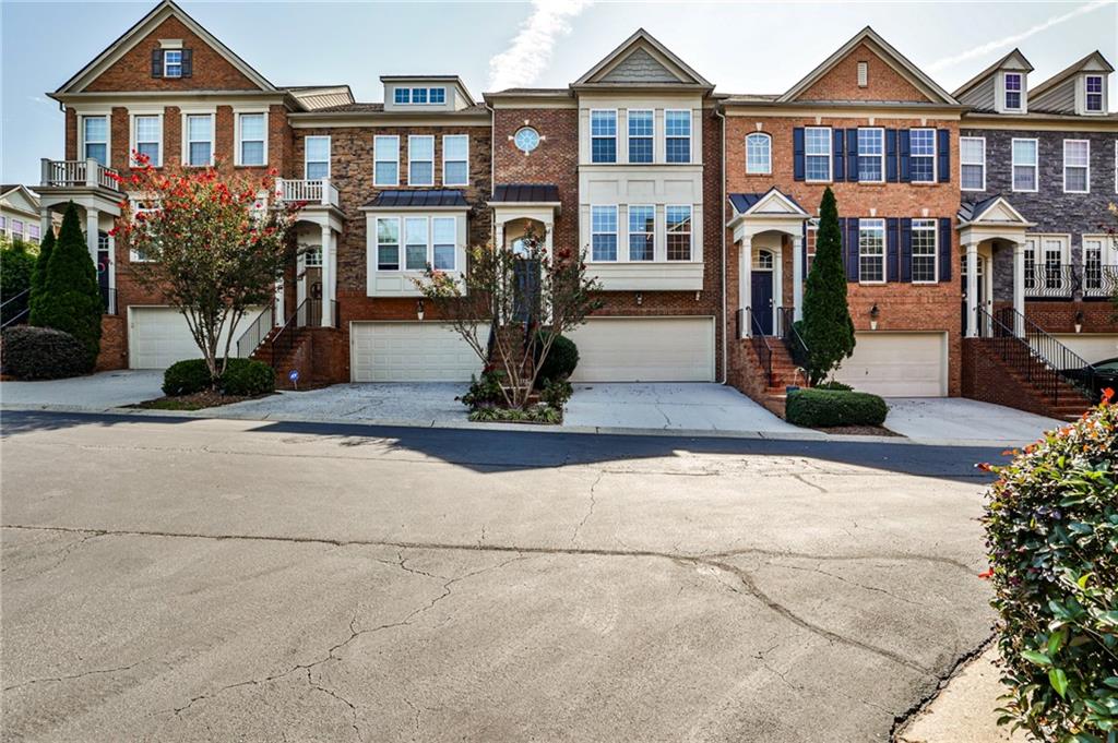 Discover spacious townhome living in the heart of Smyrna with this 4-bedroom, 2 full bath, 2 half bath residence offering 2,430 sq ft in the sought-after Westwood Terrace community. It’s all about the location—just three houses to your right from the Silver Comet Trail, bringing outdoor recreation right to your doorstep. Shopping is only a block away, and major highways including I-285/75/20 are minutes from home, making commuting effortless. A striking two-story foyer with a chandelier welcomes you into the home. The main floor is designed for both everyday living and entertaining, featuring hardwood floors, a cozy fireplace, stainless steel appliances, and updated modern light fixtures that elevate the open-concept kitchen, dining, and living areas. Step outside to the private porch off the living room, perfect for relaxing or entertaining outdoors. A convenient half bath completes this level. Upstairs, the oversized primary suite offers a true retreat with a spa-inspired bath featuring a double vanity, separate shower, soaking tub, and walk-in closet. Two additional bedrooms provide ample closet space and share a full bath, offering plenty of room for family or guests. The finished basement includes a flexible bedroom perfect for a guest suite, home office, or additional living space, along with a half bath, laundry room, and two-car garage with ample storage, adding convenience and functionality to everyday living. Step outside to your private backyard patio, perfect for relaxation. Enjoy the community pool right outside your front door, providing a true resort-style experience for relaxation, socializing, or cooling off on warm Georgia days. Perfectly situated, this home is just minutes from Vinings, The Battery, Truist Park, Cumberland, and Cobb Galleria, combining suburban tranquility with urban convenience. With the Silver Comet Trail right next door, shopping a block away, and easy access to I-285, I-75, and I-20, this location truly offers the ideal mix of lifestyle and practicality. Don’t miss the opportunity to own a beautifully maintained home in one of Smyrna’s most sought-after communities, offering comfort, style, and a prime location for modern living.