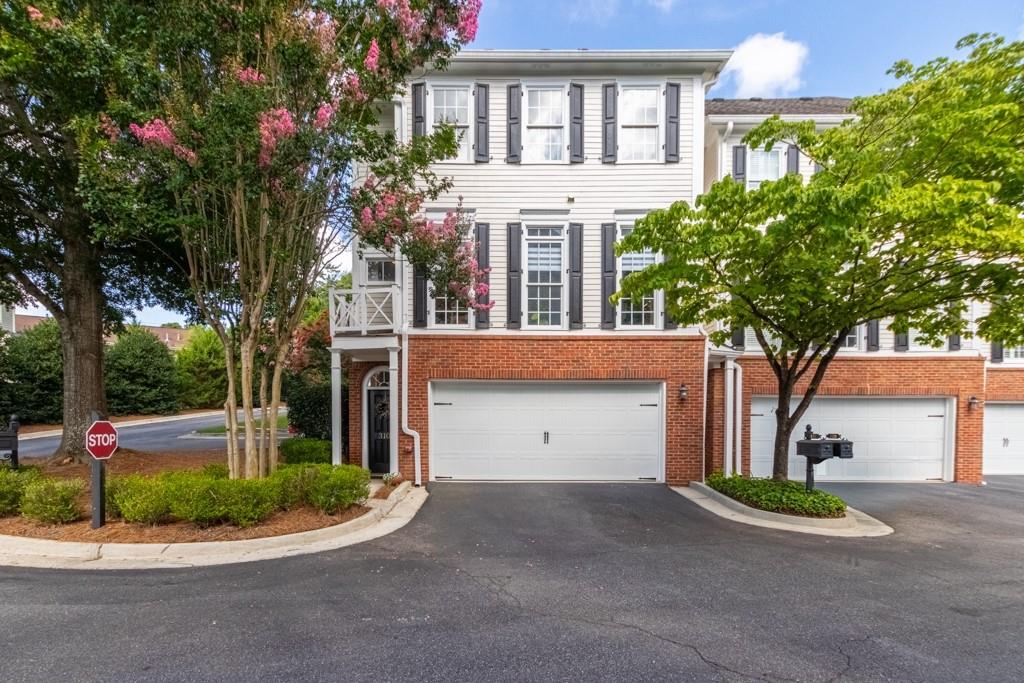 Welcome to 310 Neel Reid Dr, a beautifully maintained 3-bedroom, 2.5-bath end-unit townhome located in a quiet, gated Roswell community just minutes from the vibrant shops, restaurants, and festivals of Canton Street. Inside, you'll find hardwood floors, crown molding, designer lighting throughout, and a light-filled open layout with a fireside great room and elegant dining room framed by architectural columns and a tray ceiling. The updated kitchen impresses with white cabinetry, granite countertops, stainless steel appliances, a subway tile backsplash, gas range with vent hood, and a spacious island ideal for entertaining or casual mornings. Upstairs, the oversized primary suite offers a serene retreat with tray ceiling, natural light, and a spa-like bath featuring dual vanities, a soaking tub, and a tiled walk-in shower. Two additional bedrooms and a full bath provide flexible space for guests or a home office. Enjoy your private back deck, a 2-car garage, and extra storage all just steps from parks, trails, and everything Historic Roswell has to offer.