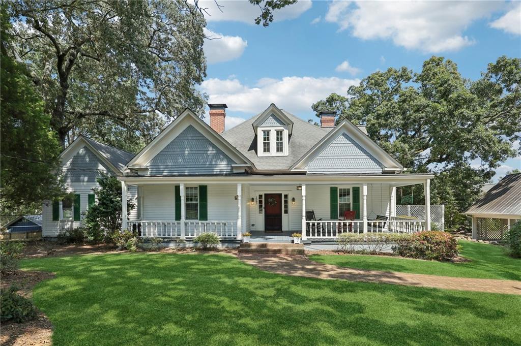 You've finally found the perfect rocking chair front porch! Welcome home to your historic Marietta farmhouse on almost 2 acres of useable land with a LAKEVIEW! Three different outdoor spaces to enjoy - large front porch with swing and plenty of space for multiple rocking chairs, side deck with FULLY FENCED in yard, and your large oversized screened in back porch with scenery of rolling hills and the lake. Sip your morning coffee and relax to the sounds of nature - birds chirping merrily, crickets humming good morning, with visits from the occasional hummingbird and butterfly. In the evenings, be inspired with a light show from the fireflies. Live out your farmhouse dreams while still being close to everything - restaurants, shopping, grocery stores - it’s all right here! Just minutes from multiple accesses to I-75 and I-575, Chastain Road, Barrett Parkway, and only a 10-12 minute drive to Kennesaw State University main campus. This home truly has it all - owner’s suite on main with large sitting room, guest bedroom on main with full bath, gleaming hardwood floors throughout, recently painted interior, brand new windows installed 3 three years ago throughout, all systems maintained and in healthy condition. Brand new water heater installed earlier this year. Property lines go up to the shore of the lake and the acreage is surrounded by Heritage Farms neighborhood which has a walking trail to the lake so you can experience it up close. Lake can be enjoyed from multiple locations inside the home as well, including the eat-in-kitchen room as well as the bonus recreation room. Back section of property connects to cul-de-sac inside Heritage Farms - have confirmed with county and HOA that it could be subdivided and sold if desired to build a second home in the neighborhood. Or, keep all your acreage to use as a wonderful backdrop of greenery, for your enjoyment. Own this home and become a part of the prestigious unofficial “Blackwell Road” club, with all it’s perks it has to offer including wonderfully friendly neighbors- you'll find many of them out and about using the many sidewalks throughout the day which can take you to scenery like two nearby horse farms as well as little libraries, one of which is next door. Not to mention the pure historic value that you'll be a part of - the original home of the Mack Dobbs family! The current owners have loved every minute of being in this home, they just need to move closer to family which is why they are letting it go. Home has been lovingly cared for and all it needs now is YOU!