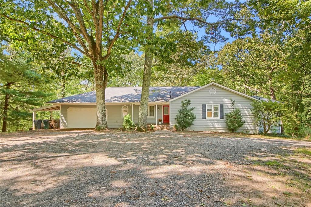 Welcome to your own private retreat on 2 acres with NO HOA! This spacious 4-bedroom, 4-bath ranch with a full finished basement offers comfort, versatility, and a beautiful natural setting.
Inside, you’ll find lots of space with living areas full of natural light. The updated kitchen features a 2-year-old GE French door refrigerator along with a KitchenAid stove, microwave, and dishwasher—combining modern convenience with timeless style.
Just off the kitchen and large dining area, an inviting family room with vaulted ceiling and a wood-burning fireplace creates the perfect spot for gathering. The generous owner’s suite with skylighted oversized bath opens into a stunning sunroom with more skylights. Two oversized secondary bedrooms and a full bath complete the main level.
The fully finished basement expands your living space with two large rooms (ideal as extra bedroom, office, or exercise spaces), plus a full bath, a spacious open living area with wood-burning stove, a large laundry room, and tons of storage, including unfinished areas and under the stairs. This level’s separate plumbing and private exterior exit provide the possibility of income potential, if desired.
Outdoor living shines here with an expansive back deck overlooking wooded views, a large backyard with storage shed, wooded acreage to explore, and a welcoming front porch offering lovely pastoral views of the neighboring horse farm.
A two-car garage (with attic space for extra storage above), plus an extra carport and large circular driveway provide plenty of parking and make coming and going easy! A newly installed Starlink satellite system with a 150-foot buried cable ensures simple, reliable internet connectivity.
This property delivers the perfect balance of privacy and convenience—just minutes from Hwy 400, the outlet malls, and all that North Georgia has to offer.