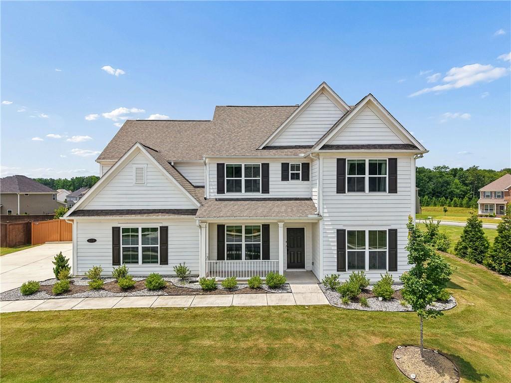 Traditional-style residence featuring white siding and dark shutters