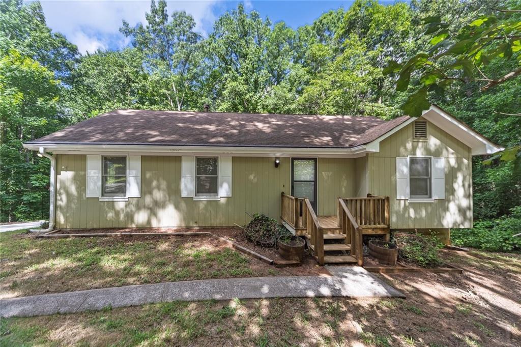 Nestled on 2.1 acres in a peaceful, non-HOA community in Ball Ground, this charming ranch home offers the perfect blend of privacy and convenience. Enjoy one-level living with a welcoming family room centered around a cozy wood-burning fireplace, a dining area, and a kitchen outfitted with warm wood cabinets and all appliances, including a washer and dryer. The primary bedroom includes an adjoining bathroom, while two additional bedrooms share a hall bath. A two-car drive-under garage leads to an unfinished basement area with potential for a workshop or additional living space. Surrounded by nature and offering ample space to spread out, this property provides a serene retreat with easy access to nearby amenities. You are just minutes away from Hwy 20, offering shopping, dining, medical facilities, and easy access to I-575.