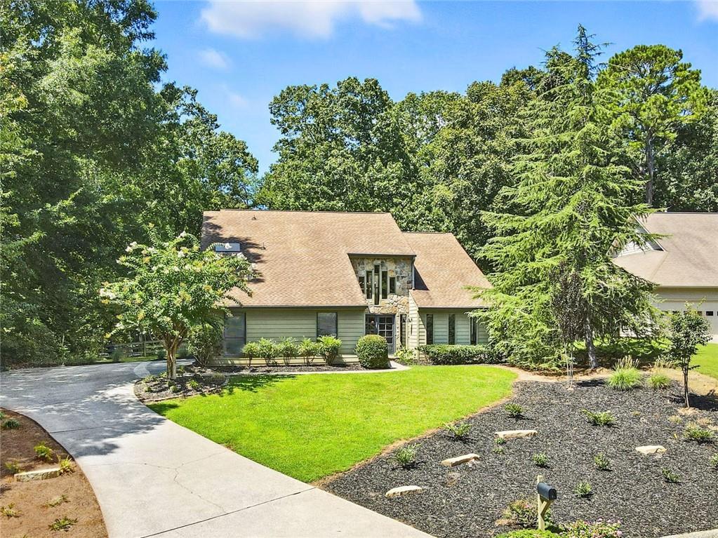 WELCOME HOME to this unique, updated 5 bedroom, 3 bath home nestled on a quiet cul-se-sac street in the highly sought-after lake community of Loch Highland in East Cobb! Award-winning Lassiter High School District! This fabulous contemporary home features thoughtfully appointed finishes throughout, vaulted ceilings, loads of natural daylight, convenient guest suite on the main level, and so much more! The main living level includes a light, bright two-story foyer, vaulted formal living room— great for a home office or flex space, formal dining room, guest bedroom, full guest bathroom, large laundry room, spacious fireside family room, and gorgeous eat-in kitchen complete with quartz countertops, premium appliances, waterfall breakfast bar, custom pantry, and adjacent breakfast area with dry bar and beverage cooler. Upstairs, you’ll find 3 sizable guest bedrooms, guest bathroom, and the enormous primary bedroom with vaulted ceiling, fireplace, and spa-like ensuite bath including separate custom vanities, large walk-in double shower, separate soaking tub, and large walk-in closet! This home offers plenty of opportunity for outdoor entertaining or just relaxing on the large deck with convenient retractable awning, overlooking the rare, flat fenced-in backyard! EV Charging station in garage. The active Loch Highland community offers two swimming pools, tennis courts, lakes and walking paths, and is located near shopping, dining, entertainment, and more! Don’t miss the opportunity to make this amazing home your own!