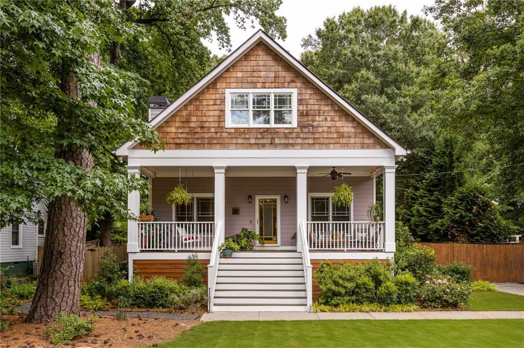 Nestled on a lively, tree-lined street, this classic Craftsman in Parkview blends timeless character with curated updates and standout curb appeal. A flat front yard and manicured landscaping lead to a wide front porch that sets an inviting tone before you even step inside. Inside, the floor plan strikes a rare balance: open and connected for everyday living and entertaining, with plenty of space to spread out and recharge. Hardwood floors, coffered ceilings, and built-in details add warmth and authenticity, while thoughtful updates keep the home feeling fresh and functional. The oversized living room features custom shelving and a cozy fireplace, flowing seamlessly into the generous dining area and bright, open kitchen. Refinished cabinetry, stainless steel appliances and a smart layout make this kitchen a true standout for everyday meals or weekend hosting. Just off the kitchen, built-in cabinetry adds stylish storage and day to day ease. Two spacious main level bedrooms and an updated hall bath offer flexibility for guests, a home office, or creative space. The elevated primary suite feels like a private retreat, complete with a fully renovated en suite bathroom featuring designer tile, clean lines, and a walk-in rain shower. Head upstairs where a full upper level renovation adds a fifth bedroom and third bathroom, plus you’ll find a bonus room ideal for a playroom, media zone, or dynamic guest suite that adapts to your changing needs. Step outside through French doors to your backyard oasis. A large deck, lush landscaping, and a fully fenced yard create the perfect setting for late summer BBQs or crisp fall evenings around the fire pit. The detached two car garage offers even more storage, while a remote controlled gate adds daily convenience. Located just blocks from DeKalb Memorial Park and Disc Golf, Charlie Yates Golf Course, and minutes to I 20, this home delivers the best of intown living with the comfort and charm of a true neighborhood gem.