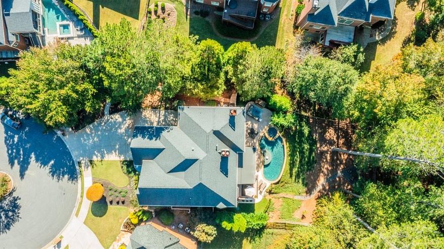 Welcome to this timeless 4-sided brick home, perfectly situated on a cul-de-sac lot with private access to The Big Creek Greenway. Just minutes from Avalon and downtown Alpharetta, this property offers both convenience and tranquility in a prime location. Step into your backyard paradise, complete with a waterfall edge pool, spa, and outdoor kitchen—ideal for hosting summer gatherings. A fireside chat area, rustic fire pit, and flat backyard provide multiple spaces to relax and entertain. Whether enjoying quiet evenings or lively get-togethers, this outdoor retreat is unmatched. The fully finished terrace level offers incredible versatility, featuring a second kitchen, theatre room, recreation room, full bedroom and bath, and abundant storage. Imagine the possibilities of linking outdoor and indoor entertaining spaces for guests of all ages. Enter through a welcoming foyer and discover a thoughtfully designed floor plan. The main level boasts: A bedroom and full bath, ideal for guests or a home office, Three distinct living areas offering ample space for relaxation, A large, separate dining room perfect for hosting formal dinners, A keeping room with a fireplace off the eat-in kitchen for cozy family moments. Access to a screened-in porch and deck, blending indoor and outdoor living seamlessly. The upper level includes 5 spacious bedrooms, including the primary with fireside lounge area, updated bathroom and abundant closet space. Enjoy 4 additional bedrooms and 3 full baths, along with a large laundry room. Each room is designed for comfort, with natural light and functional layouts. Don't miss the 3 car garage with plenty of storage. Roof, all windows and water heaters have been recently replaced. This home also has a generator in case of power outages. Facing east/northeast, enjoy top-rated schools, including Creek View Elem, Webb Bridge Middle, and Alpharetta High School. It's a quick jaunt to the Windward Lake Swim and Tennis Club, neighborhood schools and a short drive to Avalon and GA400. This meticulously maintained home is a rare combination of luxury, functionality, and location.