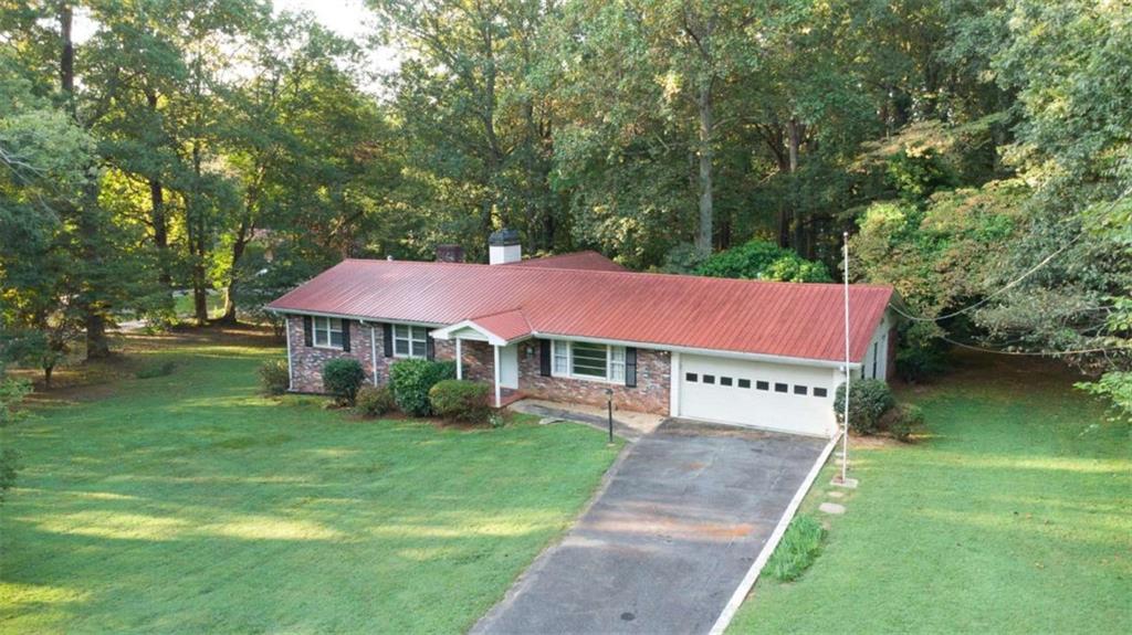 Welcome to this charming 3-bedroom, 2-bathroom ranch home perfectly situated on almost 2 private acres in the heart of Forsyth County. Offering over 2,000 square feet of living space, this property combines comfort, versatility, and convenience in one. Step inside to discover a spacious floor plan highlighted by a large extra den with its own fireplace, creating the perfect retreat for a cozy family room, home office, or even a secondary primary suite. The unfinished basement provides endless opportunities for storage, hobbies, or future expansion. Outdoors, the property truly shines. With nearly 2 acres of private land, you'll have plenty of room to garden, entertain, or simply enjoy peaceful surroundings. A small barn/shop adds bonus space for storage, a workshop, or recreational equipment. The private backyard makes the ideal backdrop for family gatherings, pets, or relaxing evenings under the stars. This home is tucked into a convenient location, just minutes from shopping, dining, and commuter routes, while still offering the serenity of country-style living. Families will love being zoned for the award-winning Forsyth County school district, one of the most sought-after in the area. And with no HOA, you'll have the flexibility to make this property truly your own. Whether you're searching for a comfortable ranch home with room to grow or a property with land and freedom, this one checks all the boxes. Don't miss the chance to make this Forsyth County gem your next home!
