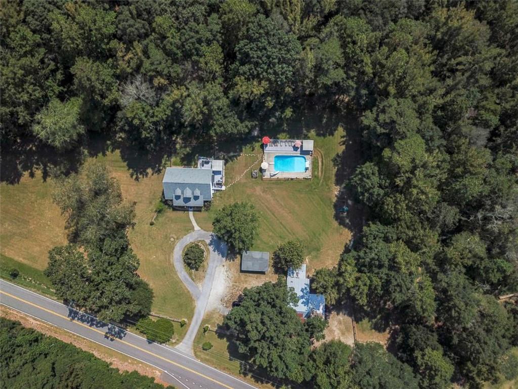 Welcome to country living on almost 10 acres while being conveniently located just 6 minutes to I-85, 24 minutes to Hartsfield Jackson International Airport, and 10 minutes into Peachtree City. You have access to renowned Fayette County Schools: North Fayette Elementary, Flat Rock Middle School, and Sandy Creek High School. This beautiful Cape Cod style home has 4000 sq ft of finished living space that includes a master bedroom, along with one other bedroom and powder room on the main level, 2 bedrooms and a full bathroom upstairs, and a full-finished basement with bedroom, full bathroom, and kitchenette. The basement would make a great in-law suite with it's own entrance. There is an in-ground pool with new pool deck, new liner/filter/pump replaced in 2022, and 100 year old barn with horse stalls and a pasture! The roof is 4 years old, water heater 5 years old, and HVAC is serviced regularly and coil replaces in 2025, plus the home has a newly built front porch and back deck. All the drain lines to the septic field were replaced in 2017. The interior has been freshly painted and newer floors have been installed. The current owner added 2 sliding glass doors from the kitchen/eat-in area to the back deck which wraps around the side of the home. Under the back deck is a covered and fenced patio area. You can access this from the basement as well as from the upper deck and back/side yard. The kitchen has new, leathered, granite counter tops, and painted cabinets. Updated lighting has also been added throughout the home. If you have horses, there's a perfect spot for them in the barn and plenty of space to graze and roam in the pasture. If you don't have horses, you could use the barn for storage. There's a circular driveway and parking area for you and guests, in addition to the covered parking pad. The home has been well taken care of for you so all you need to do is pack your bags and move in!