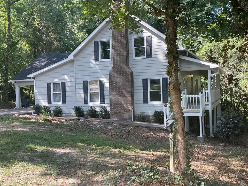 So much has been done by the owner to benefit the new folks buying this home. The exterior has been freshly painted in a beautiful modern gray color. The interior walls, ceilings, and trim are all freshly painted. Wall to wall new flooring has been installed, with attractive luxury vinyl plank in the downstairs living areas, and brand new carpeting in the bedrooms. The owner recently replaced the roof and the heating and air conditioning and water heater, all within the last three years. Even the septic tank is recently serviced and inspected. The crawl space is freshly lined with thick plastic to control moisture and keep things clean and tidy. The gutters contain Leaf Filter guards for easy maintenance. This home features a relaxing porch off the side, overlooking a wooded area which appears to be an unbuildable lot. The primary bedroom and dual vanity bath are on the main level. Two additional oversized bedrooms are upstairs. The separate dining room sports a new light fixture. The family room is very large and includes a wood-burning fireplace. It will be a wonderful family home in a quiet, established, neighborhood in Snellville close to restaurants and shopping.