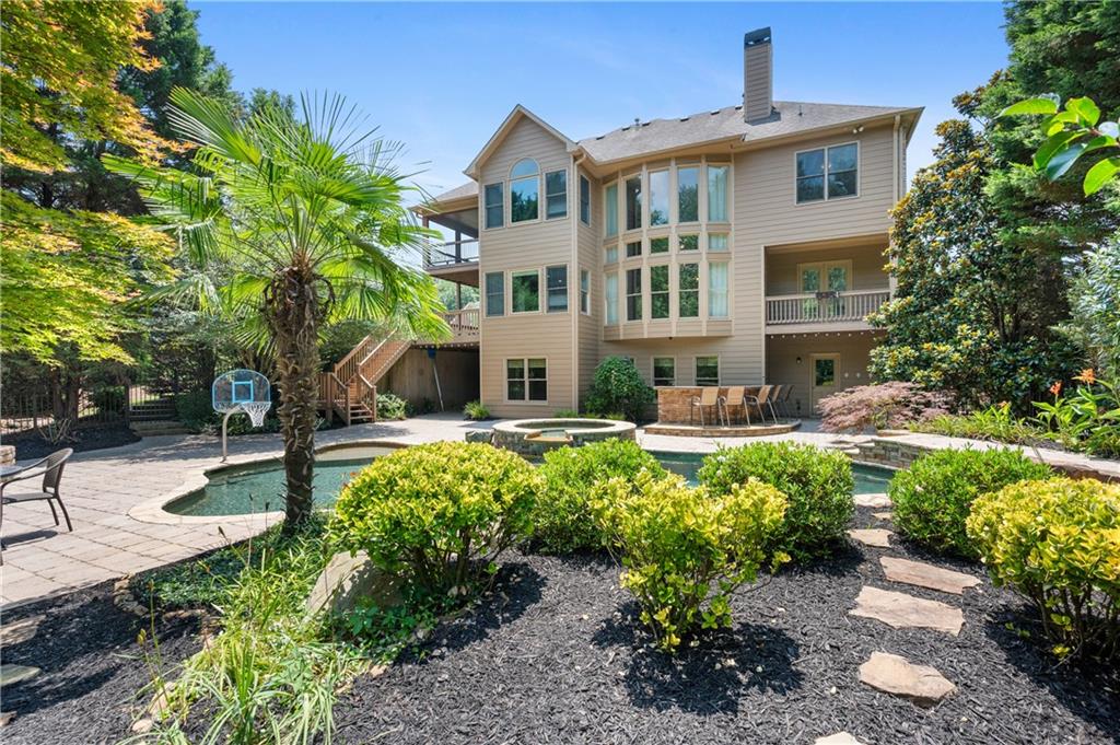 Elegant 4 bedroom, 4.5 bathroom home, 3 sides brick and a 3 car garage, on a beautifully landscaped lot spanning over half an acre in the highly sought-after Olde Heritage swim/tennis community. Ideally located just minutes from Downtown Woodstock, Milton, and Alpharetta, this spacious residence is designed to offer comfortable living and a private retreat. A charming brick-paved rocking chair front porch welcomes you into a two-story foyer and main level boasting hardwood floors, formal dining with trey ceiling, formal living room, and a unique study hidden behind bookshelf doors that opens to a private deck overlooking the pool. The great room features a fireplace and a wall of picture windows, flowing seamlessly into a bright breakfast room and a well-appointed kitchen with granite countertops, stainless steel appliances, ample cabinetry, and access to a large deck. Upstairs, the expansive primary suite includes a sitting area, its own deck, walk-in closet, and a spa-inspired bath with soaking tub, dual vanities, and separate shower. A second ensuite bedroom and two additional bedrooms with shared bath complete the upper level. The finished terrace level adds potential for a fifth bedroom, and boasts a flex room, full bath, family room, and storage, ideal for guests, teens, or multigenerational living. Step outside to your private backyard oasis featuring a sparkling pool with hot tub section, stone pavers, fire pit, fenced yard, and covered outdoor kitchen prep area perfect for year-round entertaining. The three-car side-entry garage includes a Tesla charger. Don’t miss this rare opportunity to enjoy lifestyle, space, and location in one of Woodstock’s most desirable neighborhoods.
