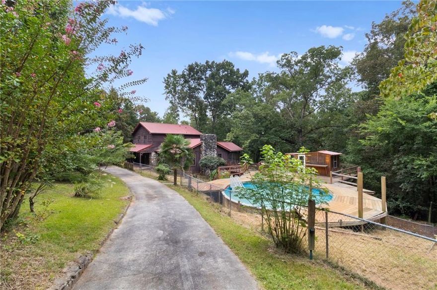 PRICED TO SELL, PRICED ~$200K BELOW AREA COMPS! This 4 bed/3 bath home on over 1 acre by Lake Allatoona with a pool could be perfect for a Fix & Flip, Buy & Hold, Airbnb, or owner occupant looking to invest some sweat equity. Home comes with two separate lots over a half acre each! Keep both to have over an acre, build on the other lot, or sell it as a buildable lot! Unique opportunity to own this one of a kind property walking distance to the Wilderness Camp Marina! Home in need of cosmetic updates. Large semi-circle driveway with 2 car carport leading to the covered front porch. Massive deck surrounds the above ground pool and a small outbuilding that could be a pool house with a bar/serving window. Huge living room offers exposed beams, vaulted ceiling, fireplace, views to the kitchen, and access to the screened in porch. Large kitchen offers new granite, tons of cabinet and countertop space, an overhang perfect for barstools, and a large dining area. The huge Master Bedroom offers a private deck, fireplace, and En-suite with double vanity and tub/shower combo with jacuzzi tub. Upstairs provides 3 bedrooms and a secondary bathroom with large vanity and tub/shower combo. The huge basement offers tons of additional living space. Huge bar area/second living room/recreation room with fireplace, full bathroom, and large room that could be repurposed with endless possibilities. Access to the garage area in the basement. Outside there is a screened in porch, massive deck that surrounds the pool, outbuilding on the deck with tons of potential, storage building, and private lot.