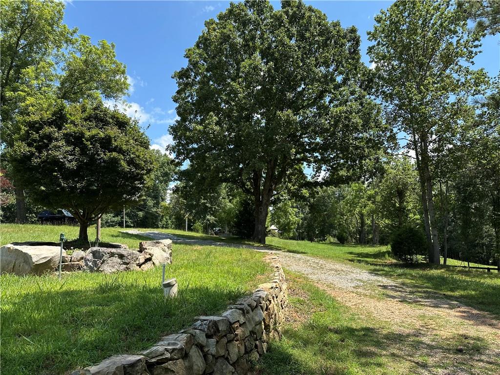 Incredible opportunity to own property in Milton with the space to build an exquisite estate with your house perched up on a hill like a castle to survey all of the nature around you. This lot is set up perfectly to build a house made out of glass and absorb the wildlife that lives all around you. Privacy like this is hard to find. With 8+ acres, you have plenty of room for whatever hobbies you may have. This property zoned AG is at the end of one of Milton's few and coveted gravel county roads, where horse farms dominate. A creek on the property line gives you access to year around water. If you are looking for a property on a quiet street away from the sounds of traffic, then this is the property for you. If you want additional acreage, more is available that is adjacent to this. Less than 5 minutes to the Birmingham Publix and 7 Acre bar and restaurant and 20 minutes to downtown Alpharetta, provide close and easy luxury shopping while feeling rural.