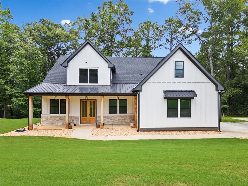 Welcome to this exceptional 4 bedroom, 4 bathroom modern farmhouse nestled on a beautiful wooded 1.36 acre lot with NO HOA. Designed with both elegance and comfort, this home boasts soaring 10-foot ceilings on the main and breathtaking two-story windows that flood the space with natural light. Step inside the double front door to find LVP flooring, a dramatic floor-to-ceiling stone fireplace in the living room and a chef's dream kitchen! The kitchen features inset soft-close cabinetry, quartz countertops, a black granite island with an apron-front farmhouse sink, double ovens, a pot filler and stainless steel appliances. Just off the kitchen is a fabulous and spacious butler's pantry with space for a wine-fridge. A charming breakfast area overlooks the covered patio, perfect for enjoying morning coffee or hosting guests. You'll also find a separate formal dining room and a convenient butler's pantry for easy entertaining. The main-level primary suite is a true retreat with a spa-like bathroom offering a marble double vanity, a luxurious soaking tub, and a separate tiled shower. An additional bedroom on the main level makes an ideal office or flexible guest space. Upstairs, a beautiful staircase leads to a versatile large, open loft area, along with two generously sized bedrooms and 2 full bathrooms - one bedroom has an en-suite bath. This energy-efficient home is equipped with spray foam insulation, a tankless water heater and a spacious 3-car garage. With timeless charm and modern features, this home has everything you could ask for.