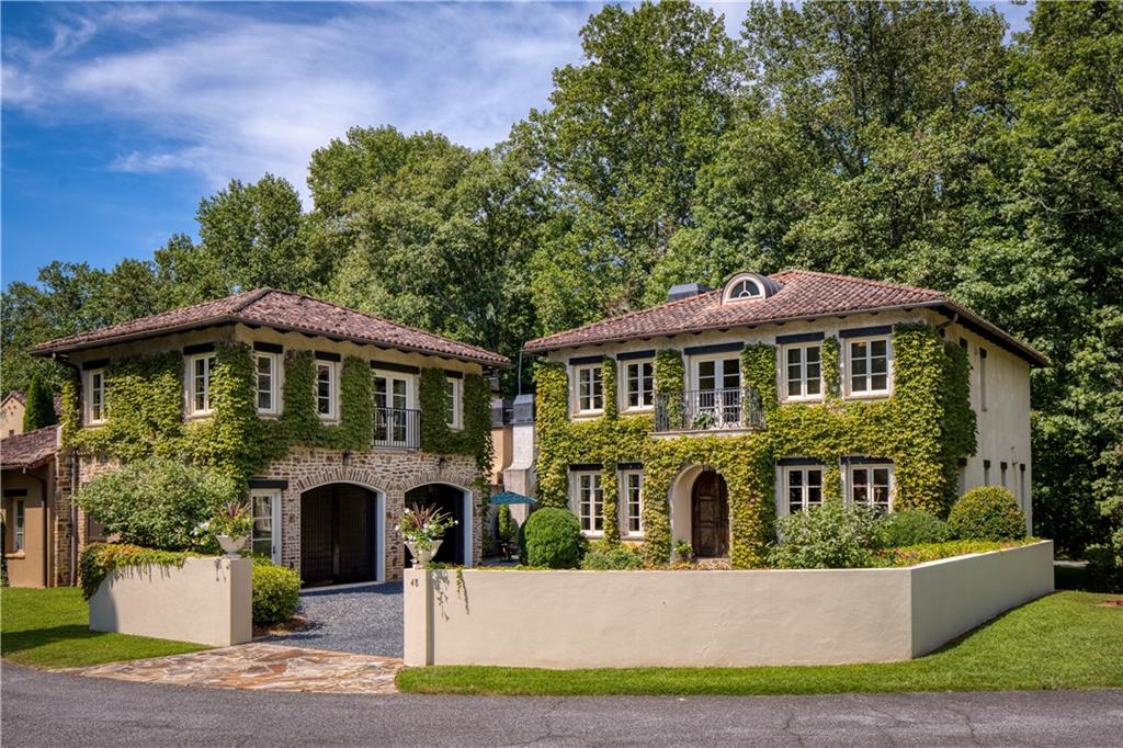 Tuscan Villa with Vineyard & Mountain Views – Nestled in a Private Enclave of Italian-Style Homes, this 6BR/6.5BA VILLA with CARRIAGE HOUSE offers a rare NORTH GEORGIA RETREAT with its' TIMELESS BEAUTY. Designed by Architect Bulent Baydar and built by the AWARD-WINNING Beecham Group, it features an Authentic ITALIAN TILE ROOF, BEAMED CEILINGS, TWO FIREPLACES, WOODEN PLANK FLOORS, and Exquisite TUSCAN-STYLE MILLWORK, radiating OLD-WORLD ELEGANCE reminiscent of the Italian countryside. Draped in ivy, soon to glow with FALL COLOR, this Home feels like an ESCAPE TO THE OLD WORLD – a place to gather la famiglia and create memories with Family and Friends.
Step through the ARCHED WOODEN FRONT DOORS into the FOYER, where SUNLIGHT fills the DINING ROOM and MAIN-FLOOR GUEST SUITE with VINEYARD VIEWS, while the BEAMED FAMILY ROOM with FIREPLACE flows to one of TWO TERRACES, ideal for "al fresco" entertaining. The CHEF’S KITCHEN is a true centerpiece, featuring a GENEROUS ISLAND, SOLID-STYLE ITALIAN CABINETRY, and Abundant NATURAL LIGHT. The KITCHEN overlooks the FAMILY ROOM and opens to the FLEX ROOM, which highlights a WALL OF WINDOWS and is perfect as an OFFICE or EXTRA SITTING AREA for ENTERTAINING.
A COURTYARD WITH FIREPLACE and TWINKLING LIGHTS creates an ambiance straight from a Mediterranean piazza, offering a serene and magical setting for EVENINGS UNDER THE STARS. Upstairs, the PRIMARY SUITE boasts a BEAMED CEILING, CLAWFOOT TUB, WALK-IN SHOWER, and DOUBLE VANITIES, accompanied by TWO ADDITIONAL SPACIOUS ENSUITE BEDROOMS. The NEWLY FINISHED BASEMENT opens to another OUTDOOR TERRACE, while the CARRIAGE HOUSE provides a PRIVATE RETREAT for GUESTS or IN-LAWS.
Priced based on the recent professional valuation. For the discerning Buyer seeking GRANDEUR, PRIVACY, and a home made for ENTERTAINING, this VILLA blends ELEGANCE with a LIFESTYLE steeped in TUSCAN CHARM. Enjoy TERRACES, a COURTYARD FIREPLACE, SPARKLING POOL, BOCCE, RIVER TRAILS, and nearby DINING at MONTALUCE WINERY & TRATTORIA – your own slice of la dolce vita. All just minutes from HISTORIC DAHLONEGA. Meticulously maintained with NEW HVACS, NEW TANKLESS WATER HEATER, and a NEWLY FINISHED BASEMENT, this home is MOVE-IN READY!