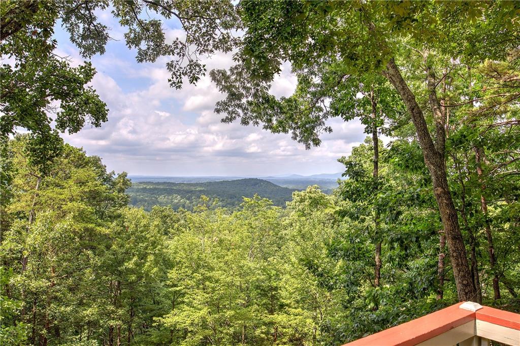 Welcome to this beautifully updated home in the gated community of Bent Tree, perfectly positioned on 2.02 acres with stunning long-range, year-round mountain views. Enjoy true one-level living with two bedroom suites on the main floor, each offering renovated bathrooms — the primary suite boasts hardwood floors, access to its own private screened porch, and a spa-like updated bath. The renovated 2022 kitchen is a chef’s dream with a Thermador refrigerator, KitchenAid dishwasher, electric range and compactor, custom soft-close cabinetry, workstation sink, new quartz countertops, and designer backsplash. A bright dining area and two inviting sunrooms make perfect spots to soak in the view. Downstairs, the terrace level provides excellent additional living space with a family room, guest bedroom, a sunroom, and workshop — ideal for hobbies or storage. The main level also includes a convenient laundry room and two-car carport, while the easy driveway and close proximity to the back gate add to the home's everyday convenience. Additional features include a partial home generator, exterior freshly repainted in 2024, and numerous thoughtful improvements throughout. This home delivers the perfect blend of modern comfort, thoughtful design, and scenic Bent Tree living — ready for you to move in and enjoy. Bent Tree encompasses 3500 acres and features 24/7 security, a 110-Acre private, stocked lake perfect for fishing and kayaking, an 18-Hole Joe Lee designed golf course, tennis and pickleball courts (both inside and outside), two pools, a beach area, hiking trails, water falls, its own fire department and water system, a dog park, bocce ball court, basketball court, horseshoe court, playground, boat storage, boat launch area, clubhouse, restaurant, waterfalls and hiking trails.