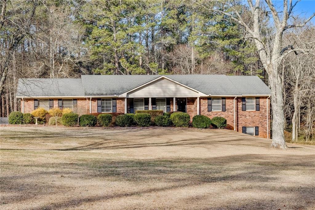 This charming four-sided brick ranch is nestled in the highly desirable Harrison School District and boasts timeless original charm! The home features a master on the main level, two additional spacious bedrooms, and two bathrooms, all meticulously maintained. Situated on a rare and stunning 3.5-acre level lot, the property offers a gorgeous front and back yard, a turnabout driveway, and ample privacy with wooded surroundings. Inside, enjoy an expansive multi-living room area, a separate dining room suite, and a full walk-out daylight basement with a workshop area, as well as a two car garage with an adjacent storage room. Recent upgrades include a 2-year-old HVAC system. Outdoors, a covered back porch adorned with decorative summer vines overlooks the serene backyard, complete with a shed for extra storage. With no HOA, this property combines peace and convenience, located near plentiful shopping, dining, and recreational activities of Kennesaw and Marietta. This property won't last long! Schedule your showing today!!