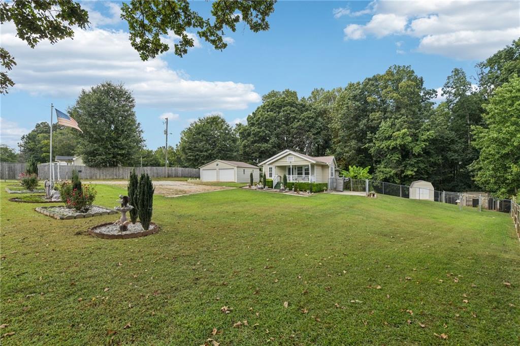WELL MAINTAINED 3/2 HOME ON 1.10 ACRES- No HOA & No Fees! TWO CAR GARAGE (LARGE ENOUGH FOR YOUR BASS BOAT), GREAT OUTDOOR ENTERTAINING AREA, TWO OUTBUILDINGS, CHICKEN COOP & LARGE USABLE FENCED YARD!! Don't let the age of this home fool you as it was taken down to the bones just before the current owner purchased it & he has just had the true hardwood floors refinished, new carpet installed in the bedrooms & fresh paint added to a portion of the interior. You'll love the flexibility this floorplan provides allowing you a great office space if you don't need the separate dining room, and the choice of an Enormous Family Room/Recreation Room if you don't need the third bedroom. Enjoy the Great Outdoor Area which provides a large tiled patio w/gazebo & enclosed structure which provides natural light making it Perfect for large gatherings and/or year round play space. Feel free to bring your furry friends & chickens as there is already space for both. PLEASE NOTE: the property extends well into the woods beyond the fenced area allowing you even more space to romp & build a fort or tree house if you'd like. :-) Conveniently located to I-985, Gainesville & NE GA Medical Center & just across the street from Hall County Fire Station #1 which should provide fast service if needed & lower insurance rates. You will definitely want to schedule an appointment to preview this one!