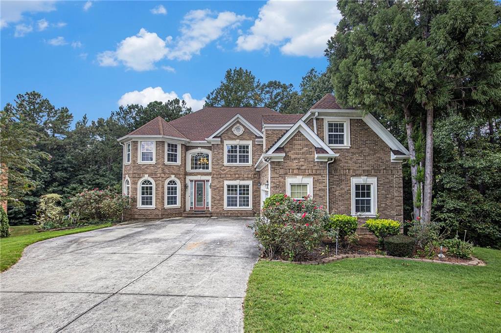 This stately four-sided brick home with an unfinished basement offers endless potential! The main level features a dramatic two-story family room with a cozy fireplace, an eat-in kitchen with solid surface countertops and stainless-steel appliances, a guest bedroom, laundry room, formal living room, and dining room. Upstairs, enjoy a spacious primary suite with a sitting area, spa-like ensuite with double vanity, separate soaking tub and shower, and a walk-in closet, plus three additional bedrooms. A deck overlooks the backyard, and the home includes a two-car garage. Located in the highly sought-after Westlake High School district, this property offers convenient access to shopping, Downtown Atlanta, major interstates, the airport, and more!