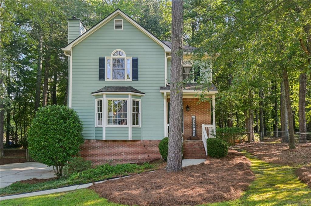 Step onto the tree-lined lot of this 3-bedroom, 2.5-bath home and you’ll immediately notice the character that sets it apart. With its inviting front porch, brick accents, and a soft green exterior framed by mature trees, this home balances warmth and style before you even walk through the door.
Inside, the kitchen steals the show with custom gray cabinetry, stainless steel appliances, and marble-inspired counters that create both function and design appeal. An easy flow between spaces makes it perfect for everyday living and hosting friends.
Upstairs, the primary suite offers vaulted ceilings, an airy feel, and plenty of natural light. Two additional bedrooms provide space for family, guests, or a dedicated office.
The screened-in porch extends your living area outdoors, giving you a comfortable spot to unwind while overlooking the wooded backyard.