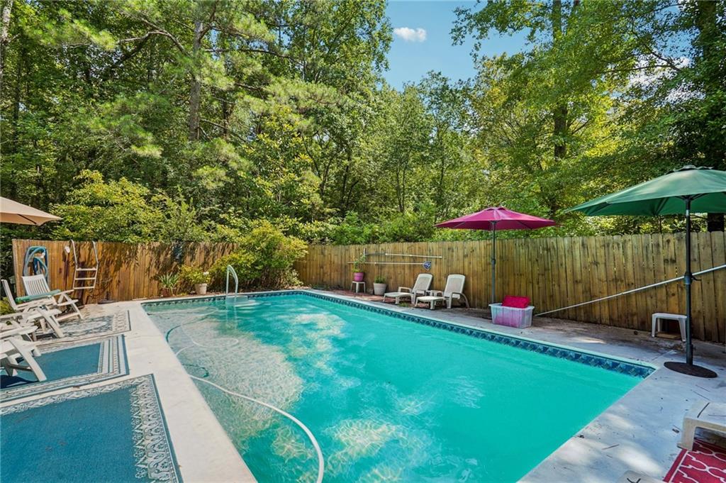 Move right in and vacation all year long in this charming and very well-cared-for home that offers space, comfort, and great outdoor living on a beautiful 1.1-Private acre lot. Features include, an updated eat- in kitchen, a full basement—partially finished and ready for your personal touch—plus an additional garage space perfect for extra storage, hobbies, or a workshop. Separate drive to the back is perfect and super convenient for Home Shop/Office etc. Step out onto the large rear deck, ideal for entertaining or relaxing, with scenic views of your private swimming pool. Don’t miss the opportunity to be in convenient proximity to I-85, but still enjoy peaceful living, inside and out. This is a great price for all this home has to offer. Come see for yourself.