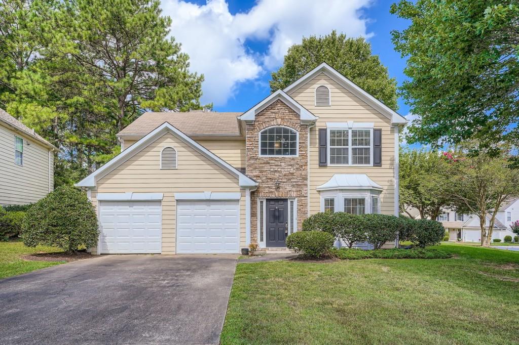 Charming Stacked Stone Front with newer hardi plank siding perfectially situated on a flat, landscaped lot in a peaceful, one entrance neighborhood. One step through the front door into the two-story foyer flows seamlessly through three attractive arched openings into the living and dining rooms with picture moldings below the chair railing . Abundant natural light from the bay window creates an inviting space ideal for entertaining and relaxing. It features 9 ft. ceilings and durable LVP flooring. The heart of the home is the generously sized family room with a fireplace, conveniently located just off the eat-in kitchen. Whether hosting gatherings or enjoying everyday moments, this spacious room is designed for comfort and function. The kitchen boasts refurbished cabinetry, a good size pantry, and double windows that flood the space with light. New uptodate quartz counter tops with a new sink, spray faucet, new blinds, newer disposer, new stainless steel gas stove, 5th burner, and a new stainless steel front dishwasher welcome you into this area with lots of counter space. Enjoy casual meals in the eat-in area which opens out to a patio overlooking the flat, partially wooded backyard. A designated garden area adds a peaceful touch to your outdoor retreat. Back inside a hallway leads to a convenient half bath and access to the spacious two car garage. Upstairs you will find a desirable split bedroom plan. The primary bedroom with a trey ceiling leads into a spa like bath with a garden tub, separate shower, long vanity with double sinks and an expansive walk in closet. Two more, very good sized bedrooms offer flexibility for family, guests or an office. More highlights include fresh, neutral decorator color paint throughout the home; . New waterproof LVP tile and toilet in full hall bath upstairs with a good size linen closet, New washer pan and light fixture installed in freshly painted laundry room. There are New double garage doors and a termite bond. Roof and hardi plank siding approximately 7 years. This home is close to the high school currently undergoing extensive renovations with additions. A very convenient location to shopping, restaurants, and major highways make this a sought after community off the beaten path. Don't miss this opportunity to own this well maintained and thoughtfully designed home. Schedule your showing today to discover the comfort, space and beauty this home has to offer!