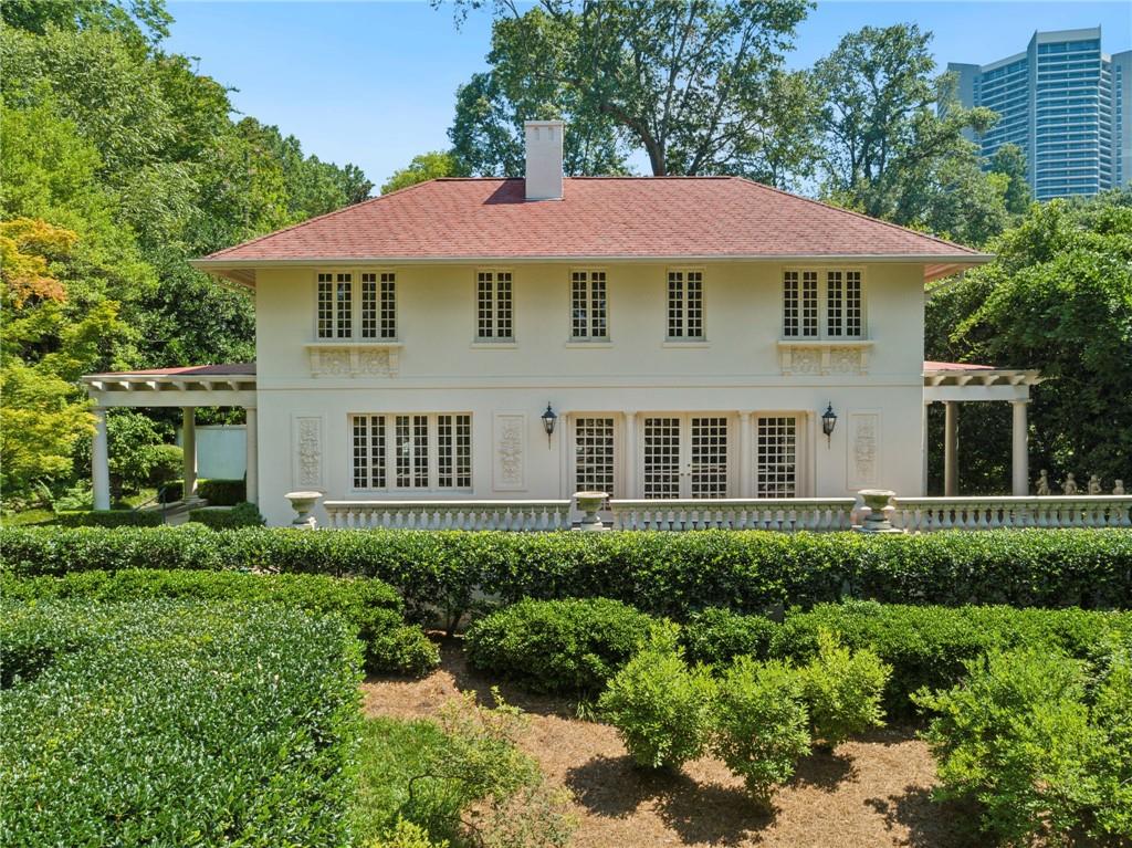 Tucked far back on one of Buckhead’s most coveted and picturesque streets, 49 Muscogee Avenue is a timeless jewel—an impeccably restored 1920 European, stucco home that radiates charm, privacy, and sophistication. Situated on a .64-acre lot, with exquisite architectural details, and magazine-worthy outdoor spaces, this historic residence offers a truly rare opportunity in the heart of Atlanta.
This home exudes an unusual sense of charm and grace. French doors open to reveal a light-filled living room, where the original fireplace, stunning plaster details, and a handsome staircase set an elegant tone.
Upstairs, the primary suite includes a cozy fireside bedroom, two closets, a private sitting room, an office or future walk-in closet, and a classic marble bath. A second upstairs bedroom also features an en-suite marble bathroom with a walk-in shower.
The living room opens to a beautiful, covered patio with elegant columns. The adjacent light filled dining room features another fireplace and stunning architectural elements. This space connects to a limestone-paved covered porch, with direct access to the gated pool and spa area—both secluded and serene.
The sunny kitchen combines historic charm with modern conveniences. Limestone floors, marble countertops, soft white custom cabinetry, and top-tier appliances are part of the well thought out design. The adjoining breakfast area overlooks the pool, while beautifully designed laundry is cleverly incorporated into the butler’s pantry.
A cozy fireside family room at the rear of the home offers built-in bookshelves and French doors opening to the garden and pool. From here, a second staircase leads to a third bedroom or office with a full marble bath, offering privacy and flexibility.
The saltwater pool with spa, is surrounded by limestone and lush landscaping, and is fully fenced and private.
This lovely jewel is in the heart of Buckhead, just moments from Atlanta’s finest schools, luxury shopping, acclaimed dining, and walkable amenities.
49 Muscogee Avenue is a landmark property that Atlantans have admired for over a century.
Welcome HOME!