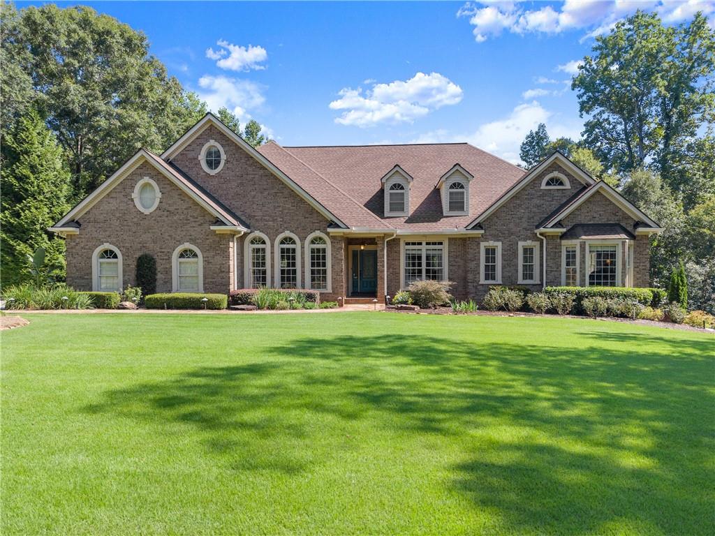 Luxury Estate on 2.24 Private Acres. Tucked within an exclusive estate lot subdivision, this sprawling 1½-story ranch blends elegance with resort-style living. The main level offers 3 bedrooms, 2.5 baths, soaring 9-ft ceilings, crown molding, hardwoods, and an open floor plan. The oversized owner’s suite features a private deck overlooking the pool. Upstairs includes a bonus room, full bath, and walk-in stand-up attic. A fully finished terrace level apartment adds a living area and 1.5 baths. The grounds are a showpiece—manicured front lawn, garden paradise with koi pond, trex decking, and a stunning inground gunite pool with pebble finish, flagstone decking and stone accents. Beyond the pool, wooded privacy leads to a fire pit retreat with stone wall and patio. A rare opportunity for refined living with privacy, beauty, and space to entertain. The property is located just 1 mile from the future home of the new Hoschton High School cluster.