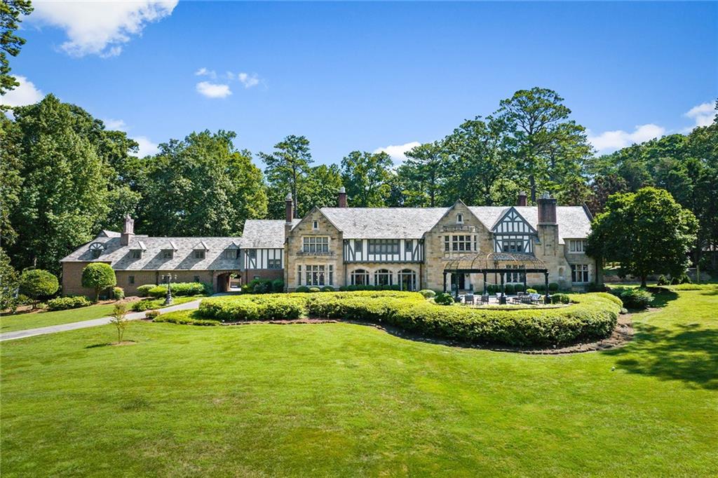 Introducing a once-in-a-lifetime opportunity to own one of the most historically significant homes in the Southeast United States, nestled within the prestigious neighborhood of Tuxedo Park in Atlanta, Georgia. This remarkable estate, originally commissioned for Samuel Candler Dobbs, the third President and Chairman of Coca-Cola and cousin to the illustrious Asa Candler, offers a glimpse into a bygone era of opulence and grandeur. Elegantly perched on a sprawling 9-acre lot, this Tudor Revival masterpiece was meticulously designed by the acclaimed architecture firm of Cooper & Cooper, showcasing their timeless craftsmanship and attention to detail. As you approach the estate, you’ll be greeted by the majesty of the hand-carved mahogany stair hall, a testament to the unparalleled artistry of the era. The grandeur continues throughout the home, with a banquet-sized dining room that whispers of historic gatherings, and a chef’s kitchen seamlessly connected to an adjoining breakfast room and keeping room, creating a perfect space for modern-day living. The estate’s interior is a symphony of sophistication and style, with an awe-inspiring glass solarium that offers panoramic views of the expansive grounds. Step outside and into your own private oasis, where the newly installed resort-quality pool beckons you to indulge in endless days of relaxation and entertainment. For your guests’ enjoyment, an upper pool and pool house provide the perfect retreat, while a tennis court adds a touch of athleticism to your days. With a caretaker’s house on the property, your needs will always be attended to. Two gated entrances, one at the front and one at the rear, provide both convenience and security, making this property ideal for entertaining and valet parking for your guests. This is not just a home; it’s a legacy, an embodiment of Atlanta’s history and prestige.
