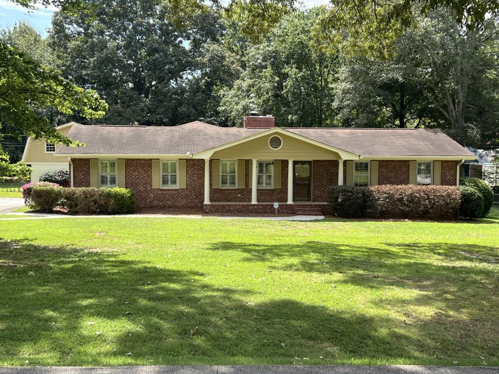 Charming traditional 4 sided brick ranch located on a lovely .77 acre level lot near the heart of downtown Snellville & Briscoe Park. Lots of space with 4 bedrooms/3 full baths. Hardwoods throughout, large family room, dining area, large kitchen, oversized owner suite, enclosed sunroom,laundry room off kitchen with lots of cabinet space. Two car carport and separate free standing large garage ideal for workshop or storage with upstairs storage area. Deck ideal for entertaining family and friends. Fenced large backyard with lots of room for kids and pets to play. Separate storage facility for greenhouse, playhouse, etc. Come see for yourself and make this home your own.
