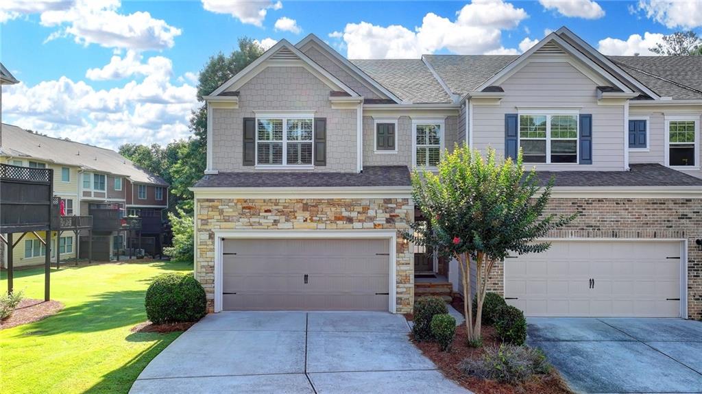 PRICED TO SELL! $90,000 Below Tax Assessment! Welcome to this exquisite 5-bedroom, 3.5-bath END-UNIT townhome with a FINISHED BASEMENT in the coveted Hillside Trace community—a rare gem! Crafted by JEH Homes, the elegant Garrett plan blends luxury and thoughtful design. From the charming stone facade to the inviting foyer and open-concept layout, this home exudes sophistication and warmth. Main Floor Highlights: • Formal dining room with tray ceiling and stunning chandelier, perfect for memorable gatherings • Gourmet kitchen with custom backsplash, expansive granite countertops, spacious pantry, and stainless steel appliances • Bright family room with cozy fireplace and soaring windows showcasing serene backyard views • Expanded deck ideal for outdoor dining and relaxing under the stars Upper Level Features: • Luxurious primary suite with tray ceiling and spa-like bath, featuring dual vanities, garden tub, separate shower, and a generous walk-in closet • Spacious secondary bedrooms offering comfort and privacy Finished Basement: • Expansive recreation room and versatile flex space (ideal as an additional bedroom) • Full bathroom, ample storage, and a stylish wet bar with sink, cabinets, and counter space—perfect for entertaining Additional Features: • Accent walls, recessed lighting, plantation shutters, and elegant chandeliers throughout • Vibrant neighborhood with top-tier amenities and zoned for the highly sought-after Lambert High School, renowned for academic excellence, alongside other top-rated Forsyth County schools with low property taxes Don’t miss this opportunity to own a sophisticated townhome in a premier location, served by one of Georgia’s most prestigious schools. Schedule your private tour today and discover the charm of Hillside Trace living!