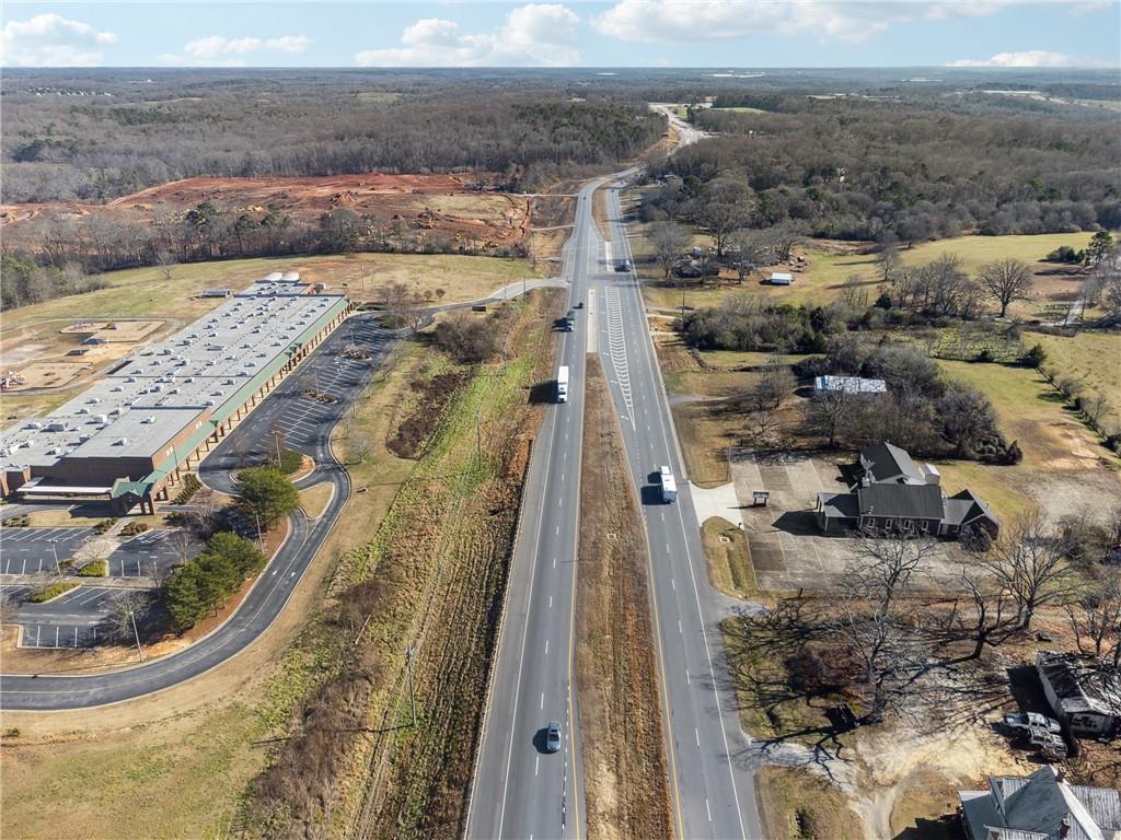 This prime 14+ acre commercial property offers over 600 feet of road frontage along the busy Athens Highway/Highway 129, situated in an area with significant growth and new developments. The land is currently zoned Agricultural, with a 3.5-acre section at the front zoned Planned Industrial Development (PID), pending survey completion. This versatile parcel is ideal for commercial or agricultural use. Additional features include a 1957-built house, a large shed/barn (approx. 27ft x 57ft), and a newly finished 1,000-square-foot building (approx. 20ft x 50ft). With an additional 9+/- acres available for purchase, this property presents a unique opportunity for various development possibilities. Note that there is a private graveyard (approx. 15ft x 7ft).