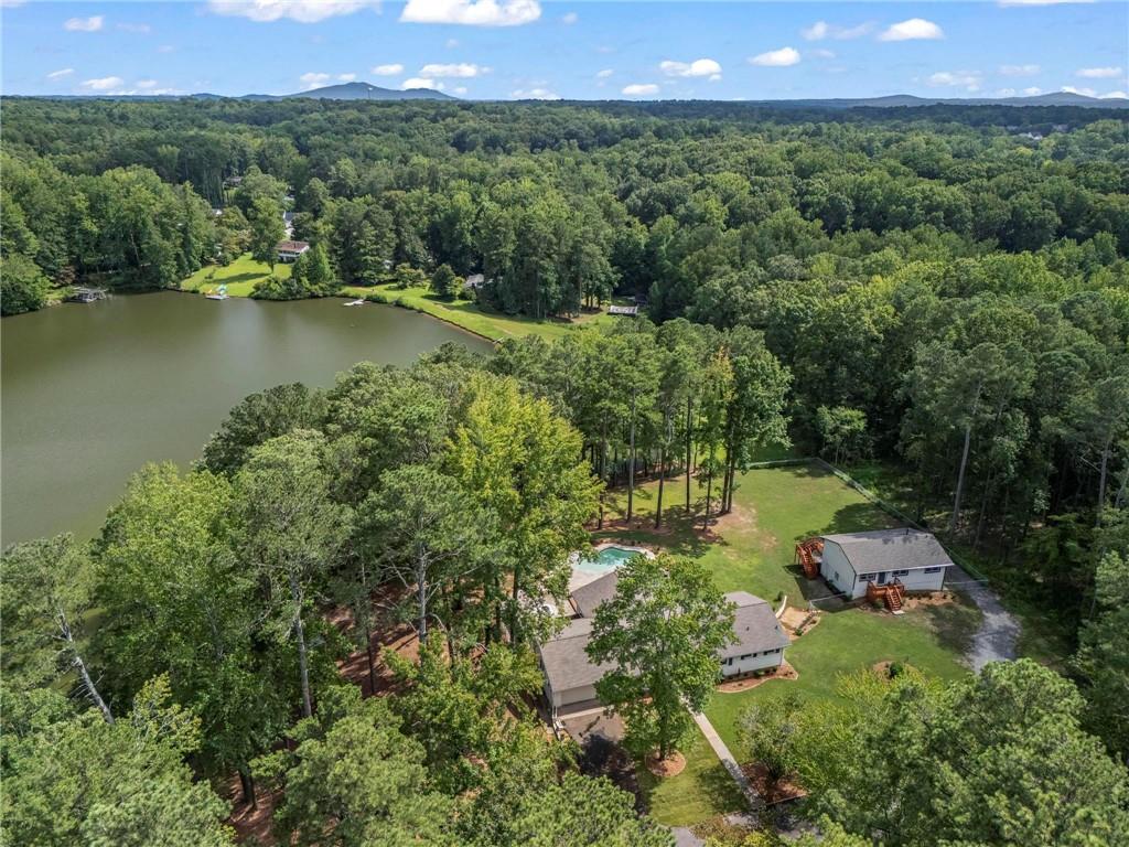 Two stunning fully renovated ranch homes on a private 3.2+ acre lakefront lot in Clearwater Estates. This rare property is perfect for entertaining with a sparkling gunite pool, hot tub, and incredible lake views. Ideal for fishing, kayaking, paddle boarding, and more. The main home has been completely updated with new quartz countertops, stainless steel appliances, windows, flooring, light fixtures, paint, decks, and landscaping. The open layout features a sunlit foyer, wide plank hardwood floors, and oversized windows. The chef’s kitchen offers quartz countertops, gas range, soft-close custom cabinetry, oversized stainless sink, kitchen island, and wood shelving. The sunroom includes a floor to ceiling stone fireplace and accordion doors that open to the pool and lake views. The oversized new deck with cable railing provides the perfect space for entertaining. The primary suite includes 2 closets and a spa-like bath with frameless shower, double vanity, and linen storage. Two additional bedrooms share a fully updated bath. The finished daylight terrace level offers luxury vinyl flooring, a possible fourth bedroom, full bath, and flex room. The second home includes 2 bedrooms, 1 bath, an open concept living and dining area, gorgeous kitchen with quartz countertops and glossy herringbone tile backsplash, stainless appliances, and a new deck with lake views. The 3-car rear entry garage and 912 sq.ft unfinished basement are perfect for storage, workshop, or recreational equipment. With two stunningly updated homes and fenced acreage, this property is the ultimate setup for multi-generational living, a guest retreat, or a private creative space. Make every day feel like a getaway-schedule your tour today!