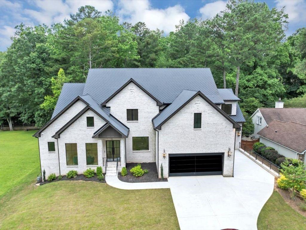 Welcome to your dream home in the sought-after Indian Hills community, ideally situated in East Cobb within the top-rated Walton High School district. This newly constructed, all-brick custom estate features 5 spacious bedrooms, 5.5 bathrooms, and a 3-car garage with sleek custom glass-and-steel doors. Inside, enjoy sun-drenched interiors, designer finishes, and oversized windows that flood the home with natural light. The covered rear porch with fireplace and the private backyard are perfect for entertaining, from intimate family gatherings to grand celebrations. The open concept main level features a state-of-the-art chef's kitchen with double islands, breakfast area, family room, keeping room, formal dining room, home office, mudroom, and powder room. The oversized main level primary suite with spa-inspired bath showcases a free-standing soaking tub, double vanities, expansive shower, and dual custom walk-in closets with pull-down hanging system and drawer storage. Upstairs offers a versatile flex space-ideal as a second living room, playroom, or media lounge-alongside four generously sized secondary bedrooms, each with its own private en-suite bath. The boutique-style laundry suite completes the upper level. The terrace level hosts a patio and unfinished daylight basement stubbed for plumbing and electric, providing a blank canvas for future customization and expansion. This home features four fireplaces, smart toilets, custom closets, a dry bar, two pantries, high-end appliances, ambient rope lighting, soaring ceilings, and handcrafted custom cabinetry-all set against pristine White Oak flooring. From the striking entrance to the extra-wide hallways, every inch has been thoughtfully designed to elevate your lifestyle and sets the stage for hosting distinguished guests or relaxing with family. Don't miss the opportunity to make this extraordinary property your Home Sweet Home! Schedule your private showing today.