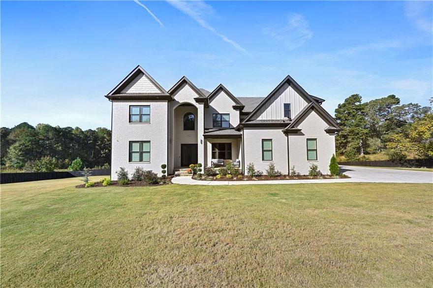 Welcome to this exquisite custom-built modern farmhouse at the heart of Buford, offering 6,000 square feet of refined living space with 5 bedrooms, 4.5 bathrooms, and a rarer 10-foot celling unfinished basement ready for your personal touch. Every detail of this home reflects superior craftsmanship and thoughtful design—from the foam insulation and clean air system to the three-zone HVAC setup providing separate comfort controls for the master suite and office, the main floor, and the upstairs. The elegant main level features a grand two-story living room with a dramatic fireplace wall, expansive windows, and hardwood flooring throughout. The gourmet kitchen is a chef’s dream with an oversized quartz island, custom cabinetry that blends functionality with style. The luxurious master suite offers a peaceful retreat with a sitting area, tray ceiling, and a spa-inspired bathroom complete with a soaking tub, frameless glass shower, and dual vanities. Upstairs, spacious bedrooms and a versatile loft provide ample room for relaxation and family time. Step outside to the covered deck overlooking the private backyard, ideal for year-round entertaining, or enjoy the quiet productivity of the expanded office space, which offers more square footage than county records indicate. With its energy-efficient systems, high-end finishes, and prime Buford location, this home perfectly combines luxury, comfort, and modern sophistication. No HOA