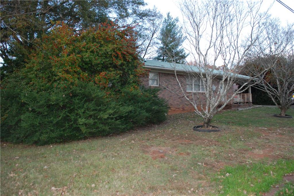 Welcome to your dream home in Cornelia, Georgia, where southern charm meets retro. This residence offers a relaxing retreat with its double lot surrounded by roads on 3 sides, ensuring you have ample space to create your very own backyard oasis.
Step inside and be greeted by a large living/dining area that promises to be the heart of your home. With 1956 square feet of interior space, this house is designed to offer both comfort and functionality. The open design encourages a flow from room to room, making it perfect for entertaining guests or enjoying quiet nights in with the family. The house boasts three bedrooms, including a master bedroom with en suite. Each bedroom comes with ample closet space. The additional two bedrooms are also well-appointed, ensuring that every family member or guest feels right at home. The kitchen features appliances and abundant cabinet space. Whether you're whipping up a quick breakfast or a gourmet dinner, this kitchen meets all your needs with ease.
Not to be overlooked, the outdoor space this property offers is truly a highlight. The large lot affords endless possibilities for gardening, leisure, and outdoor gatherings. The large garage/shop/RV storage building is a plus. Imagine summer barbecues, autumn bonfires, or simply unwinding under the stars-the choice is all yours in this personal haven. The property is a stone's throw away from shopping and recreation areas. The home is situated on quiet city streets and enjoy a walk around the friendly neighborhood visiting neighbors. This house is more than just a place to live; it's a place to thrive, offering all the conveniences of modern living in a welcoming neighborhood. It's ready to be refreshed with your touches to become the Queen of the neighborhood. Photographs shows the potential with a little cosmetic refresh.
Come check her out and make an offer today.