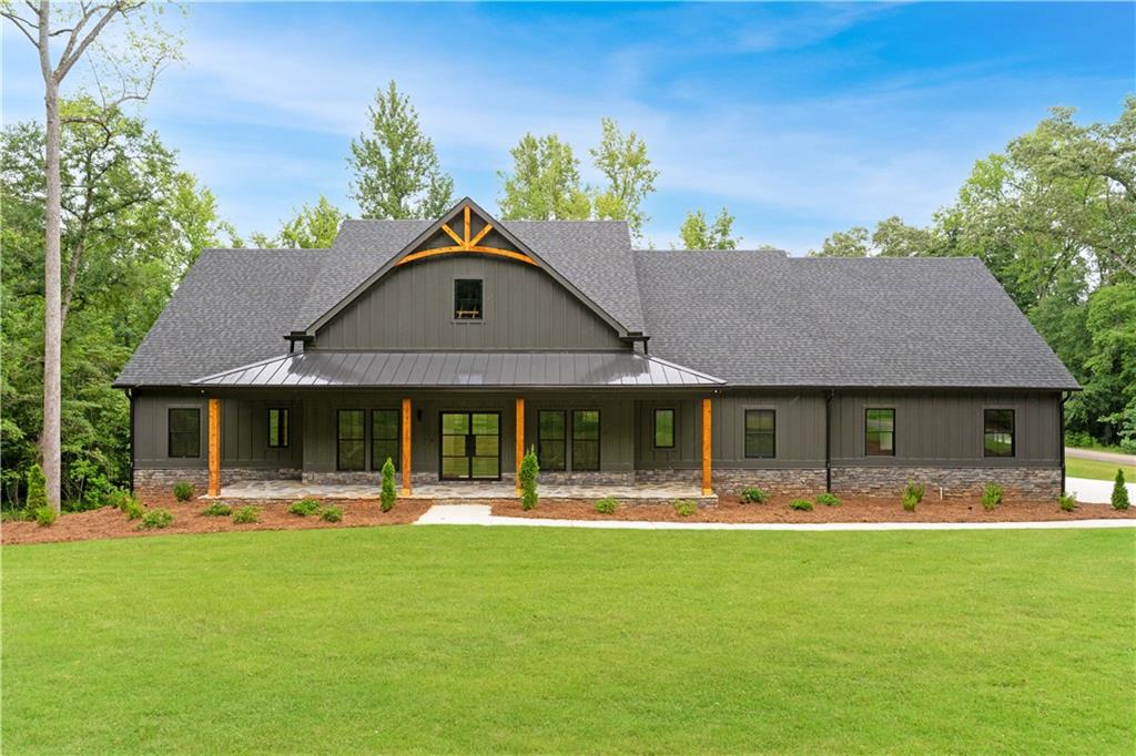 Welcome to this stunning Craftsman home nestled on a beautiful corner lot, sitting on just over an acre in a private, gated community offering 24-hour security, a clubhouse, tennis courts, swimming pools, parks, equestrian facilities, and more. As you step through the front entry you can appreciate the custom wall finishes, and the spacious foyer that sets the tone for the rest of this beautiful and custom designed home. The owner installed black Pella windows to accent the exterior. The open-concept floor plan features gorgeous oakwood floors, abundant natural light, and thoughtful touches throughout. The primary suite is located on the main level, offering privacy, warmth, and character. Highlights include a custom accent wall designed to compliment the breathtaking trey ceilings, and a stylish barn door that leads to the luxurious en-suite bathroom. Inside, you'll find a stylish soaking tub, and oversized shower with a rainforest shower head, stunning lighting, double vanities, and ample cabinetry for all your storage needs. Conveniently, the laundry room is located just off the owner's suite and walk in closet. As you continue through the home, you'll discover a dedicated office with elegant french glass doors- perfect for working from home or creating your very own work out room. The cozy living area features a fireplace with charming shiplap detailing, ideal for relaxing evenings. The gourmet kitchen is a chef's dream with quartz countertops, beautiful stone backsplash, custom cabinetry with extensive storage, floating shelves, a walk-in pantry, a double oven, an electric cooktop with a pot filler, wine cooler and stylish black fixtures. Black stainless steel Frigidaire appliances could potentially remain, making this kitchen as functional as it is beautiful. Two additional bedrooms are located on the main floor, each with its own private bathroom - perfect for guests or family members. This floor plan won't disappoint! Enter the mudroom located just off the 3 car garage with expanded driveway for you and your guests. Enjoy this large screened-in deck with a ceiling fan, outdoor TV, and fireplace and trex wood flooring, This home is designed for comfortable living and effortless entertaining. Design features include coffered ceilings in the dining room, wood beams in the family room, and a walk-out FULL unfinished basement- ready for your custom touches- with a sliding glass door that opens to a covered patio and private backyard. This community is definitely a stand-out community offering a unique blend of Golf & Equestrian which boasts of 1,000 foot of river frontage. Conveniently located about a mile from I-75.