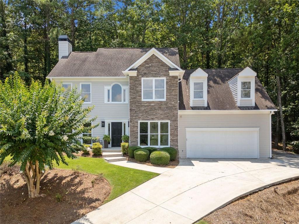 Nestled in the charming Wyngate community of Woodstock, Georgia, this meticulously cared for 4-bedroom, 2.5-bathroom residence boasts an inviting open concept design, fresh interior paint on the upper level, and a peaceful cul-de-sac location. The main floor radiates warmth and brightness, showcasing a thoughtfully designed layout. Featuring a generous space, LVP flooring throughout, a pristine white cabinet kitchen outfitted with stainless steel appliances, a stylish tiled backsplash, and elegant granite countertops, this home also includes large breakfast room windows that frame views of the patio and the serene woods behind. You'll adore the family room, anchored by a cozy gas fireplace, where abundant sunlight pours in, seamlessly connecting to the kitchen, dining area, foyer, and office. The spacious primary suite is complete with an en-suite bathroom featuring a double sink, a relaxing soaking tub, and a roomy walk-in closet. The three additional secondary bedrooms, one notably large, are ideal for children or guests. The garage is generously sized to accommodate vehicles, a motorcycle, gym equipment, and offers ample storage space. A trail in your backyard leads you to the pool and playground. Enjoy a low-maintenance yard on a cul-de-sac street in this highly desirable community with top-rated schools. Residents of Wyngate benefit from a variety of amenities, including two sparkling swimming pools, illuminated tennis and pickleball courts, a basketball court, and a playground.