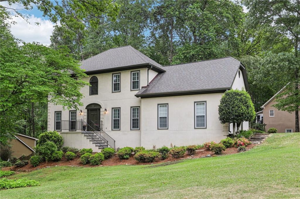 Stunning Home with Bright, Open Spaces and Serene Outdoor Living! This gorgeous residence offers bright, open spaces and exceptional attention to detail throughout. From the moment you arrive, you're greeted by a sweeping lawn dotted with mature trees and a grand front entrance that sets the tone for what’s inside. Step into the impressive 2-story foyer, flanked by a formal dining room on the right—perfect for hosting dinner parties—and a formal living room on the left, ideal for intimate gatherings or a quiet retreat. Rich hardwood floors run throughout most of the main level, adding warmth and elegance. The inviting family room features a cozy fireplace and a wall of windows that frame private, wooded views. The spacious kitchen is a chef’s dream, with granite countertops, tile backsplash, stainless steel appliances, a built-in desk area, and plenty of counter and cabinet space. The eat-in breakfast area seamlessly connects to the oversized sunroom, which includes a convenient pass-through bar—ideal for serving food and drinks with ease. A laundry room and half bath complete the main level. Upstairs, the luxurious primary suite is a true retreat with a tray ceiling, wood floors, and an expansive en-suite bath. Enjoy dual sinks, vanity seating, a fully tiled shower with a beautiful stained-glass window, and a step-up soaking tub for the ultimate in relaxation. Three spacious secondary bedrooms—two with hardwood floors—share a full hall bath with dual sinks to ensure comfort for all. Need even more space? The finished basement boasts four large areas that can flex to fit your lifestyle—whether it’s a home office, media room, playroom, craft studio, or man cave, the options are endless. Step outside to your private backyard oasis that feels like a treehouse escape. A large deck spans most of the back of the home, offering multiple seating and entertaining areas. The fully fenced yard features several tiers, perfect for outdoor lounging, gardening, or play. Located in a community with top-notch amenities including a pool, tennis courts, playground, and gazebo, and zoned for desirable Cobb County schools, this home truly has it all!