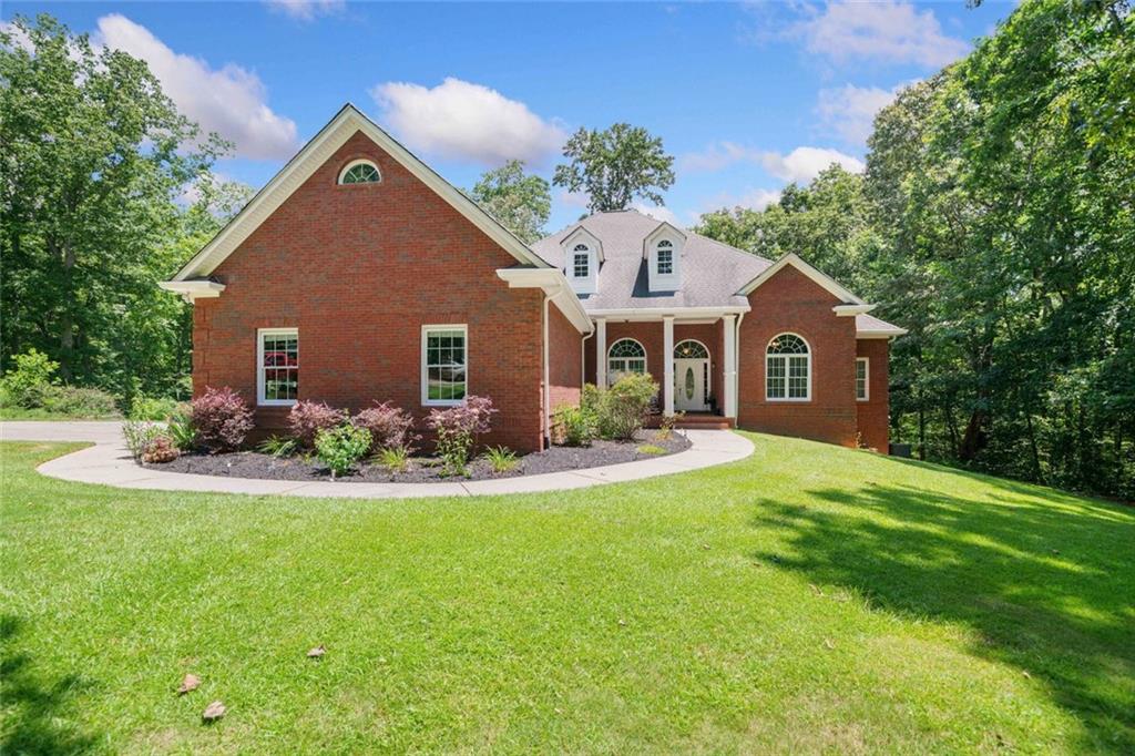 RARE FIND!!! Welcome to your Dream Home in desirable Clayton Community!! This all brick, custom ranch home with a full basement sits on 3.26 acres, offers the perfect blend of privacy and convenience. Full finished basement provides additional living space, including a home theater, game room, bedroom and two full baths. Also an additional oversized garage with room with 2 additional cars and a workshop. This open concept ranch has an large kitchen with granite counters and upgraded appliances with double convection ovens, oversized walk in pantry, and a view to the family room over a large, raised breakfast bar. It is great for entertaining. the separate dining room and separate living/office are great additional spaces on the main level. The oversized primary suite on the main has room for a sitting area, cathedral ceilings, and a spa bath. The split bedroom plan offers 3 additional secondary bedrooms on the main. The large deck off the back looks over the private backyard that does include a creek on the property. This property is not in a subdivision and does not have an HOA. The 3-car garage on the main level ensures plenty of parking and storage for your vehicles and equipment. Despite its private, open setting, the home is conveniently located near restaurants, shopping, and major highways (I-515 and I-575), Makes it centrally located for Canton, Jasper, Ball Ground, and all the major highways. This beautiful home is a rare find and has endless possibilities while offering maintenance free 4 sided brick!! Don't miss the opportunity to make this beautiful home yours!