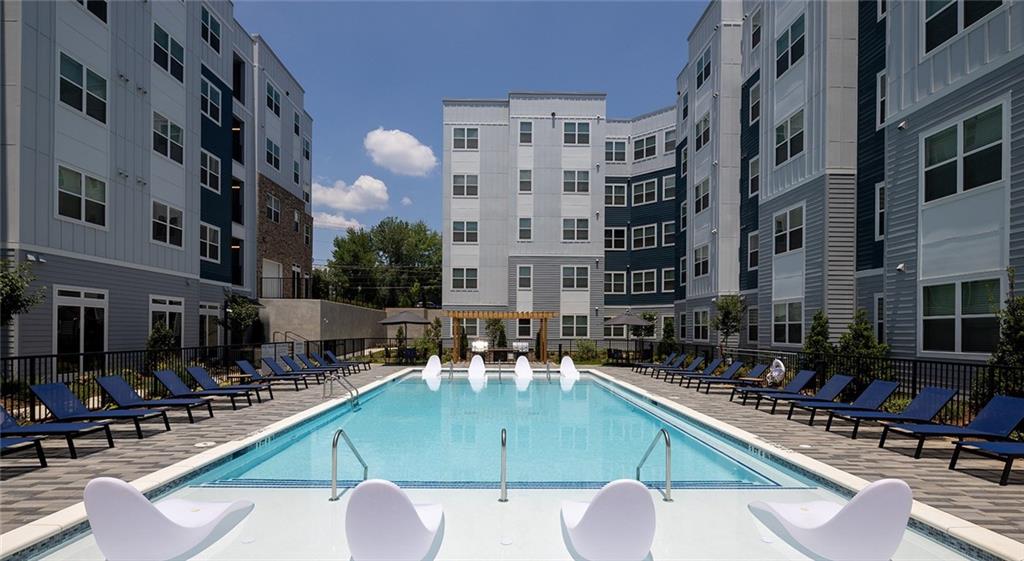 Currently offering 4 weeks free! Prices, promotions, and availability are subject to change. Come home to The Clara, a brand-new apartment community with laidback style that feels like home. Just outside historic downtown, our apartments in Norcross, GA are ideally situated in a small-town charm just outside the big city. With sweet boutiques and savory treats, parks and arts, restaurants and entertainment, downtown Norcross is a treasure trove nestled just outside Atlanta, attracting those looking for small town living and big city adventures. With its eclectic aesthetic and thoughtfully designed spaces, The Clara offers a unique blend of luxury amenities and suburban serenity. Our charming amenity spaces include a sunlit fitness center equipped with cardio machines and free weights, perfect for staying fit in a bright and welcoming environment. Unwind in our cozy club room, which features a stylish entertainment kitchen, creating the perfect space for relaxation or social gatherings with cheerful, vintage vibes.
At The Clara, the sweet life extends beyond your apartment. Enjoy our sparkling saltwater pool, ideal for a relaxing swim, or gather with friends at one of our outdoor grilling stations. These resort-style amenities provide an escape from the hustle and bustle of the big city, giving you the peace and tranquility you deserve—right here at our apartments for rent in Norcross, GA.