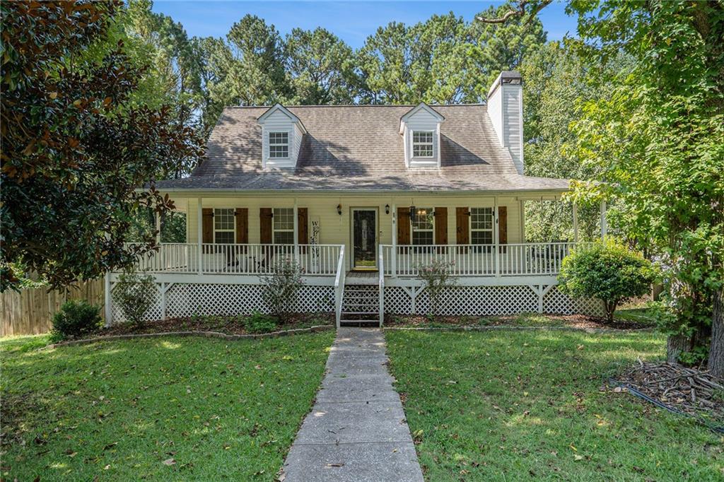 Welcome Home to the southern charm of a Cape Cod! Wrap around front porch is perfect for your morning coffee or evening chats. REAL Hardwood floors throughout the main level, recently refinished in the living area and kitchen. Cozy kitchen with a practically new refrigerator that comes with the property. Large primary bedroom with door to wrap around porch and bath with separate tub and shower, and huge closet with cedar plank floors. 2 generously sized bedrooms upstairs, along with a full bath and extra storage closet. Don't forget the basement with a finished room (could be a media room!), and a workshop room. Large corner lot with wood-fenced backyard. Excellent North Paulding High School District! Plus No HOA! Don't miss this cute-as-a-button home! Upstairs bedrooms to be painted a neutral color in the coming days.