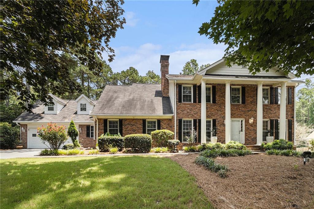 Welcome to a dream estate in Smoke Rise. Perfectly positioned on a beautifully manicured, level acre lot this timeless home combines classic charm, generous space, and design. When you step inside from the rocking chair front porch you will discover a thoughtful floorplan featuring on the main a warm and inviting formal living with dining room, a double-sided fireside gathering room with custom built-in bookcases, a full bedroom, a full bathroom, and an additional den as well as a lofted room providing versatile spaces to enjoy to the fullest. At the heart of it all is a spacious eat-in kitchen ready for culinary creations which overlooks a generously sized four seasons Sunroom. Upper level you will find four large bedrooms and an additional room that can be used as a study or creative nook with dual staircases providing ease of flow. The finished daylight basement adds more growing room potential, complete with laundry sink and versatile opportunity for expansion, two bright bonus rooms which can be used however desired or potentially as income generation. With storage galore, everything has its place out of sight. Outdoors, discover a host of features perfect for relaxation and recreation including deck, sport court, gazebo, and extra workshop building all perfectly nestled amongst a park type setting. Discover the two and a half vehicle garage with one straight drive-through open to back yard which adds extra convenience or can meet large parking requirements, and the professionally designed hardscaping as well as landscaping elevates privacy. Located next to Stone Mountain Park, shopping, dining, highways, hospitals and schools.