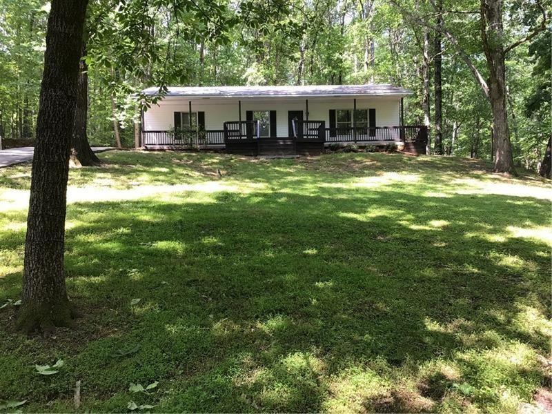 Escape to your own private retreat with this beautifully updated ranch home tucked away on 7+ acres of complete privacy. 3 spacious bedrooms plus a bonus room. 2 fully updated bathrooms with new fixtures and finishes. Modern kitchen featuring new granite countertops, custom cabinets, and newer appliances. Upgrades throughout: real hardwood flooring, stylish new light fixtures, and completely updated baths. This property offers so much more than just a home: Large outbuilding for storage, hobbies, or workshop needs. Partially fenced acreage with Bay Creek running through the property. Expansive sundeck perfect for enjoying nature and relaxing near a beautiful nearby waterfall. Not in a subdivision, and the home is not visible from the street, ensuring maximum peace and seclusion. This is truly a hard-to-find paradise in a prime location right on the Gwinnett/Walton County line.