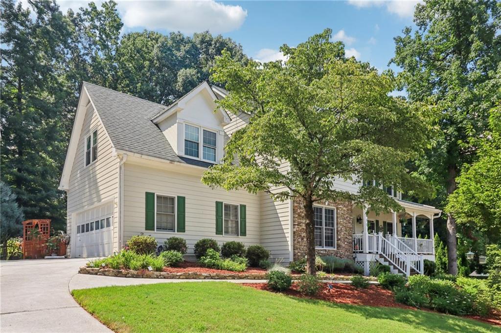 Flowers Crossing at the Mill - Brookwood School District! Tucked away on a quiet cul-de-sac in the highly sought-after Flowers Crossing at the Mill community, this beautifully maintained 5-bedroom, 2.5-bath home is a must-see. From the moment you arrive, you're welcomed by a charming front porch-perfect for unwinding with a good book or enjoying a peaceful evening breeze. Step inside to discover an expansive main level with oversized living and dining spaces ideal for entertaining. The white kitchen shines with granite countertops, stainless steel appliances, and plenty of cabinet space. Upstairs, you'll find generously sized secondary bedrooms and a spacious primary suite with a large ensuite bath. The partially finished basement offers a versatile bonus room and an additional bedroom-great for guests, a home office, or teen retreat. Out back, the professionally landscaped, fenced-in yard features a full irrigation system and provides a beautiful, private setting for outdoor living. Located in a swim/tennis community with access to top-rated Brookwood schools, this home is super clean, move-in ready, and loaded with updates.