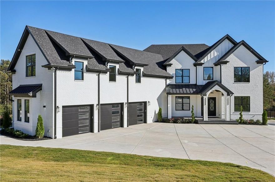 Experience refined living in this custom 6 bedroom, 7 bathroom estate, privately nestled on a fully fenced 1 acre lot with a SEWER connection. Boasting over 6,500 square feet and a full unfinished daylight basement, this home offers the perfect blend of elegance, functionality, and space. A grand foyer sets the tone with soaring 10 foot ceilings, wide plank hardwood flooring, and meticulous custom tile and trim work throughout. The open concept design centers around a true chef’s kitchen featuring high end appliances, a 48 inch built in refrigerator, double quartz countertops, a stunning waterfall island, and a full second prep kitchen ideal for seamless entertaining. The kitchen flows into a dramatic 22 foot living room with custom built ins, a cozy fireplace, and bi folding doors that fully open to the covered back deck, creating the ultimate indoor and outdoor living experience. The expansive covered porch features a built in outdoor kitchen and provides year round enjoyment overlooking the private backyard, perfect for gatherings with plenty of space for a future pool or personal outdoor oasis. This thoughtfully designed layout includes two luxurious primary suites, one on the main level and one upstairs, each offering spa like en suite bathrooms with upgraded electric smart toilets and premium finishes. Upstairs also features four additional oversized secondary bedrooms with private baths, a separate office, and a second laundry room that complements the main level laundry for ultimate convenience. Designed with comfort, lifestyle, and efficiency in mind, the home includes a whole home integrated audio system, energy efficient systems, a tankless water heater, and irrigation in both the front and back yards. The fully fenced property provides privacy and peace of mind, and the SEWER connection adds long term value and convenience. Perfectly positioned near Highway 985, Highway 85, Downtown Buford, the Mall of Georgia, and a wide selection of premier shopping and dining options, this estate delivers luxury living with exceptional accessibility.