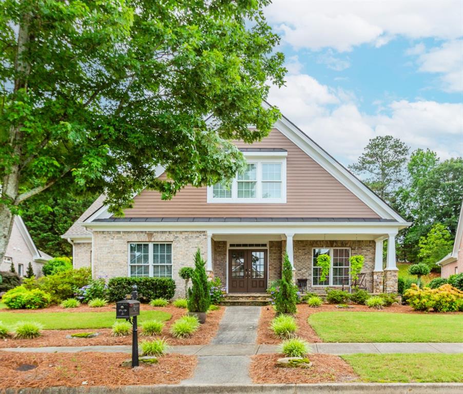 Welcome to The Preserve at Hamilton Mill! This beautiful 3 bedroom, 2.5 bath home features 4 sides brick and a charming covered front porch. Enjoy the convenience of a private rear-entry two-car garage and a low-maintenance lifestyle HOA includes lawn care. The main level offers tons of windows for natural light, a grand two-story foyer, beautiful hardwood/iron steps leading to second level, hardwoods throughout, an oversized master suite, and a laundry room spacious enough for a full-size refrigerator. The kitchen is equipped with stainless steel appliances, double ovens, a new dishwasher, and a new disposal, and it opens to a bright breakfast area and an expansive great room. Relax year-round on the covered screened rear porch, overlooking a beautifully landscaped yard requiring no upkeep. Roof and energy-efficient HVAC replaced in 2020. Upstairs, two generously sized secondary bedrooms feature walk-in closets and individual vanities with a shared tub/shower. Custom build-ins in loft area between the two bedrooms. Walk in attic space ready to be finished. Extra insulation recently added to attic making home extremely efficient for utility bills. Don't miss this well-maintained gem in a sought-after community! Just minutes to I-85 and 985.