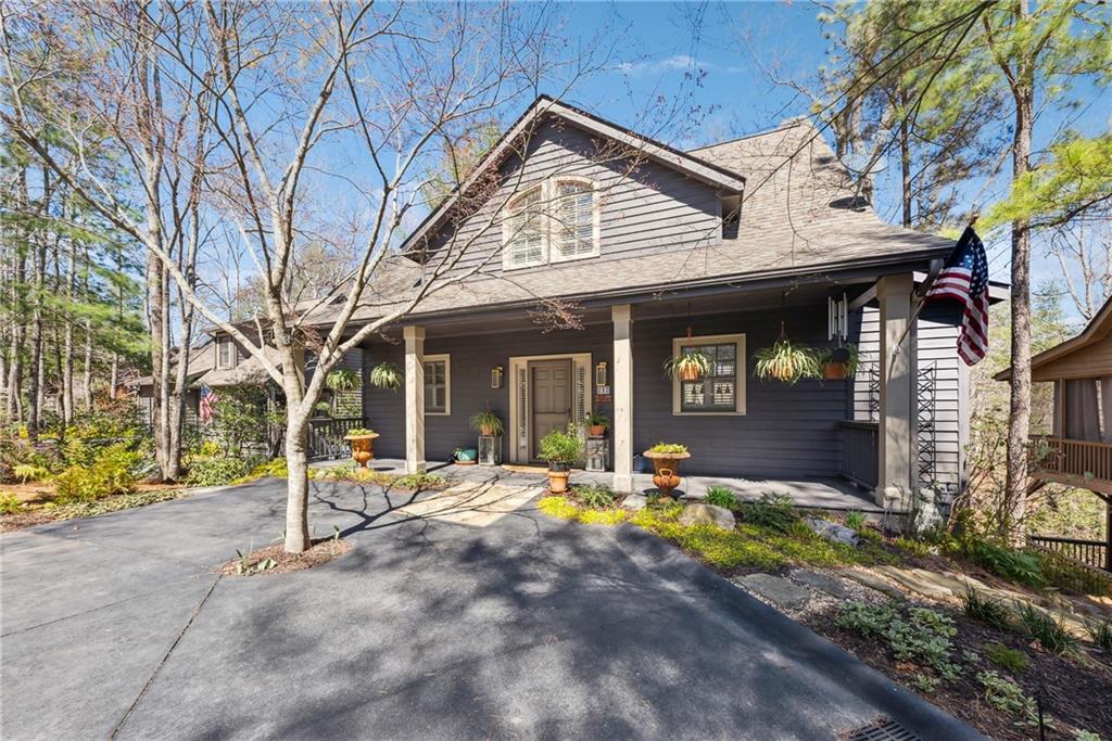 Professionally designed and like new 4/4.5 design cottage home is located in the ever-so-convenient "Wolfscratch Village" section of Big Canoe and located just seconds away from the award winning amenities which include the 18,000 SF Wellness Center, Pools, Tennis and Pickleball Courts, Chapel, Library and Clubhouse. This very special home has been transformed into an elegant masterpiece using high end products and materials throughout totaling $360,000 in improvements, all of which was done in the last 3 years. From the moment you drive up, you are greeted by luscious landscaping, a flat driveway and an inviting front porch. This gorgeous craftsman cottage features four separate in-suites, spread over three levels of open living for privacy. Walk through the front door and be greeted by a two-story wall of windows in the great room with stacked stone fireplace and high volume ceilings and hardwood flooring throughout the main level where you can also enjoy the peaceful, wood view from your enclosed sun room behind the Master BR Suite and customized bathroom with very high-end finishes and bidet. Meal prep is a dream in the open chef's kitchen with gas range, custom shaker-style cabinetry and loads of counter space. The upper level is made up of two more in-suite bedrooms and an open loft, perfect for reading or an office. The terrace level offers a large family room with custom built-ins and refrigerator, the fourth in-suite is located along with an enclosed porch with EZ-Breeze windows and stone patio floor. The list of improvements is a lengthy one and available upon request. Words alone cannot do it justice, so you'll just have to come and see for yourself.