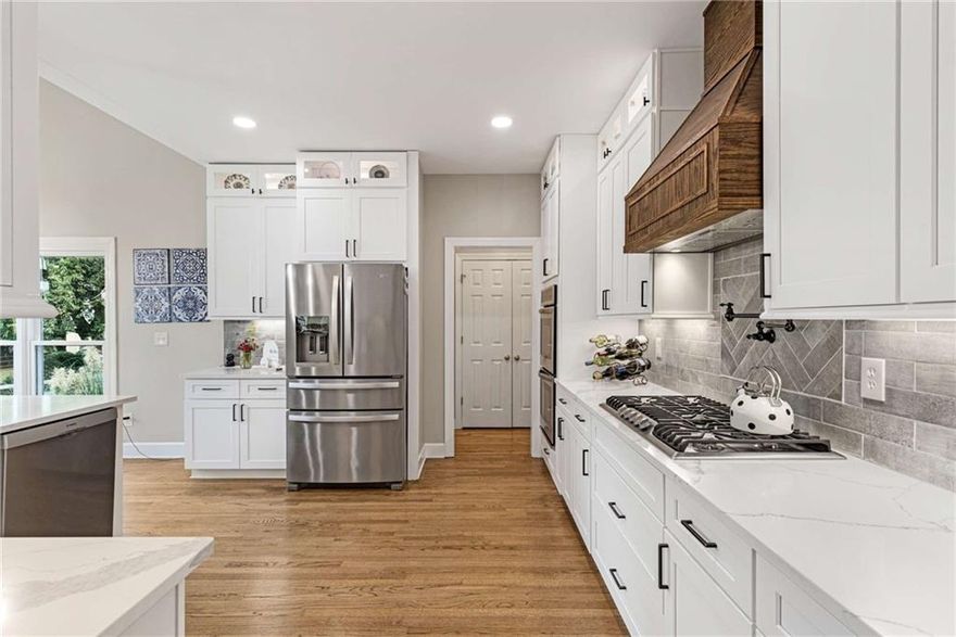 The ONE you've been waiting for in sought after Bradshaw Farm!  Discover luxury living in this gorgeously renovated home including a professionally designed chef's kitchen with white custom soft close cabinetry, custom vent hood, pot-filler, large island, stacked cabinets w/lighted glass fronts, and beautiful quartz countertops!  Designed with comfort and style in mind, this home offers 6 bedrooms, 4.5 baths, with the primary suite conveniently located on the main level.  Step into the luxurious primary en-suite with vaulted ceiling featuring elegant beams, new cabinets, quartz counters, custom tile, seamless glass shower w/dual shower heads, heated floors and free-standing tub.  Four spacious bedrooms upstairs, one with its own attached bath, all feature large closets!  The fully finished basement adds even more living space, featuring a spacious bar and entertainment tv area, flexible gym or 6th bedroom and full bath, perfect for movie nights, game days, or hosting guests. Tons of storage! Step outside to enjoy a large screened patio or the new deck overlooking the beautiful, large landscaped flat yard, perfect for entertaining and room for a pool!  This move-in ready home features a new roof 2025, Newer HVAC, newly refinished hardwoods, new carpet, new paint, new vinyl windows & more!  This home has it all and has easy proximity to downtown Woodstock, Alpharetta, Milton, Roswell and Canton.  You'll find shopping, dining and highly rated schools right around the corner.  Enjoy an abundance of amenities in this golf, swim, tennis, neighborhood.  Hurry to see!