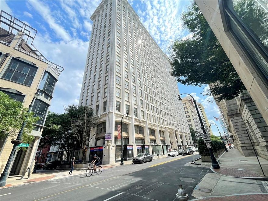 Live in the heart of downtown Atlanta in this beautifully appointed, move-in ready condo located on the 11th floor of the iconic Healey Building. Blending historic charm with modern style, this residence offers stunning views of the CNN Center, State Farm Arena, Mercedes-Benz Stadium, and the glittering Ferris wheel at Centennial Olympic Park.

Step inside to a bright open floor plan filled with natural light from expansive floor-to-ceiling windows. The living area features modern lighting and a dimmer switch for tailored ambiance, perfect for relaxing or entertaining. The sleek black countertops and matching black stove anchor the kitchen, which seamlessly flows into the living and dining areas.

The bedroom offers peace and privacy, with carefully designed shelving in the closet for efficient, organized storage. In the bathroom, unwind in a deep soaking tub—a rare luxury in the city. This unit offers energy by day and quiet elegance at night. A truly unique place to call home in one of the city’s most historically significant buildings. For private showings, please contact listing agent Tyler Moore at 404-783-3622.